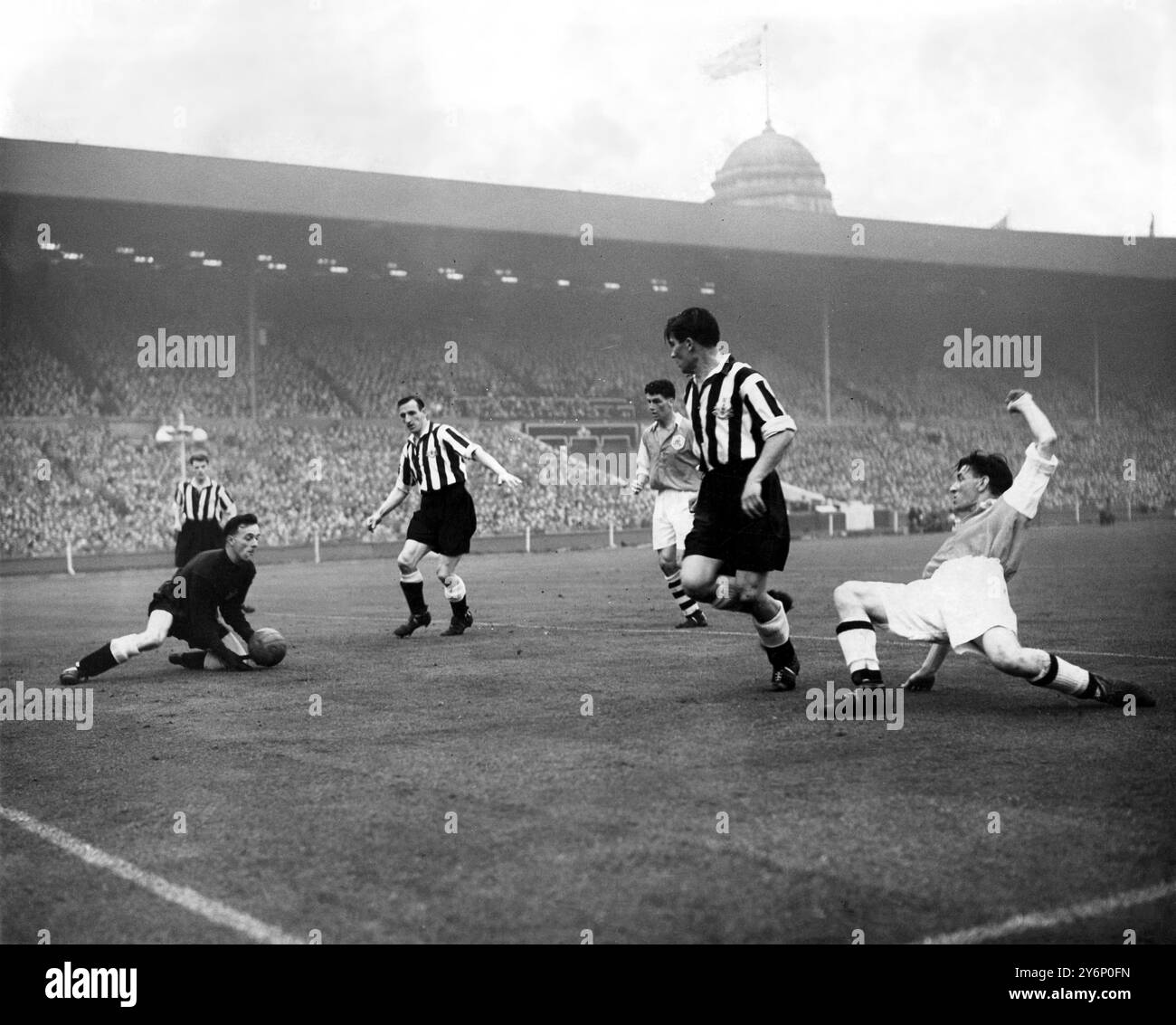 Mai 1952: Das Finale des FA-Pokals im Wembley Stadium. Newcastle United gegen Arsenal. Foto zeigt: Ronnis Simpson, der Torwart von Newcastle, geht aus, um zu retten, während der Ball während eines Arsenal-Angriffs über die Newcastle Tormündung fährt. Auf der rechten Seite ist Jimmy Logie, das Arsenal von innen. Der Newcastle-Spieler vor Simpson ist Frank Brennan, die Mittelhälfte und rechts von ihm Cliff Holton, der Mittelstürmer des Arsenals. Stockfoto