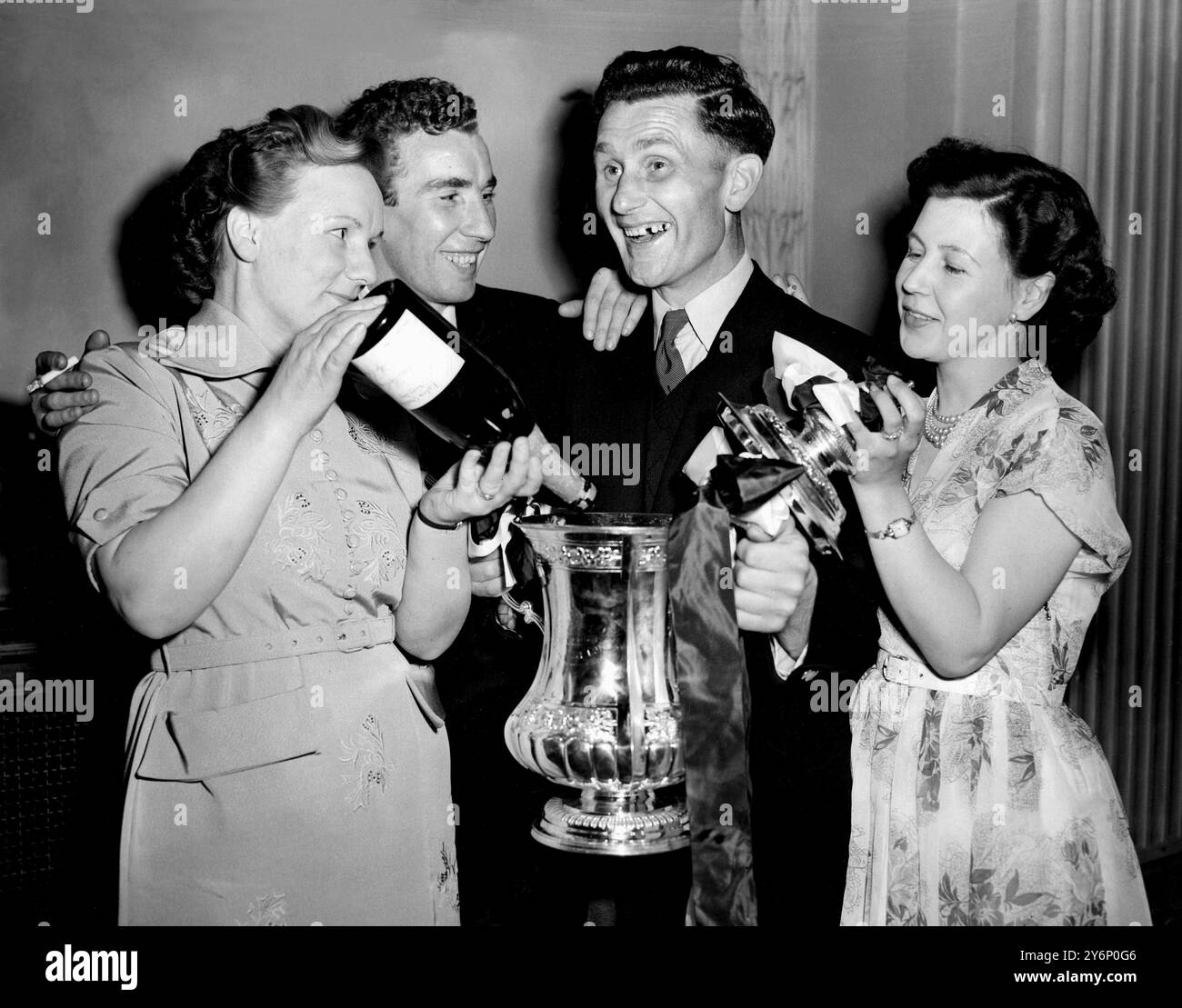 1. Mai 1954: Das Finale des FA Cups im Wembley Stadium. West Bromwich Albion (3) gegen Preston North End (2). Foto-Shows: Champagner für die Gewinner, während WBA-Kapitän Len Millard und Frank Griffin außen rechts ihre Feier genießen. Die beiden Spieler sehen zu, wie ihre Frauen im Cafe Royal, Regent Street, Champagner gießen. Stockfoto