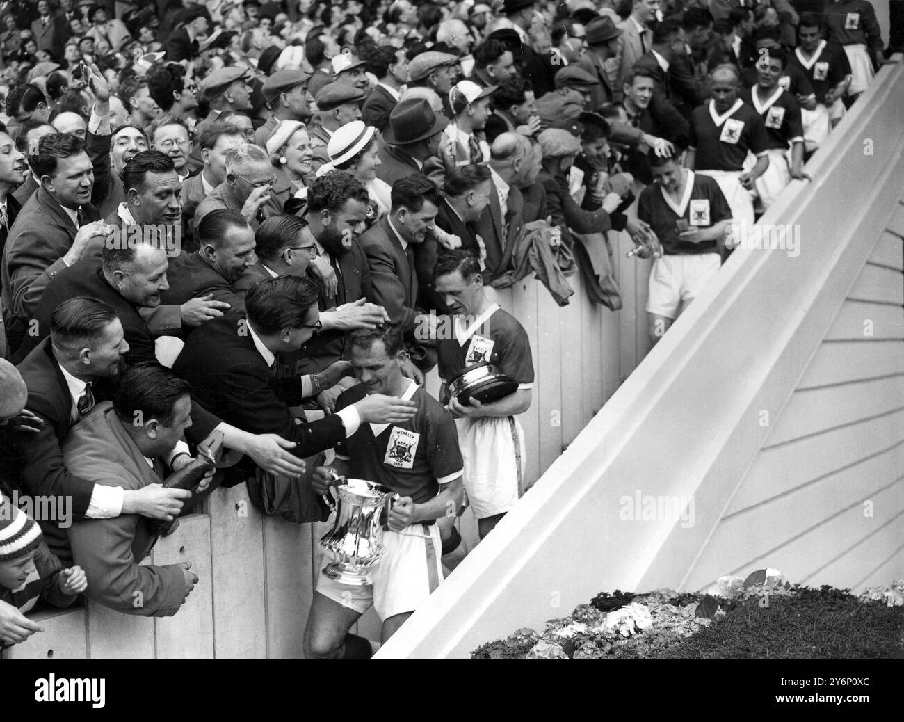 2. Mai 1959: Das Finale des FA Cups im Wembley Stadium. Nottingham Forest (2) gegen Luton Town (1). - Foto zeigt: Eifrige Hände reichen aus der Wembley-Menge, um das siegreiche Nottingham-Team zu berühren. Die Trophäe wird von Captain Jack Burkitt nach der Übergabe durch die Königin getragen. Stockfoto