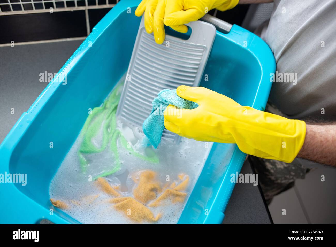 Handwäsche von Kleidung und Entfernung von Schmutz und Flecken mit einem Waschbrett Stockfoto