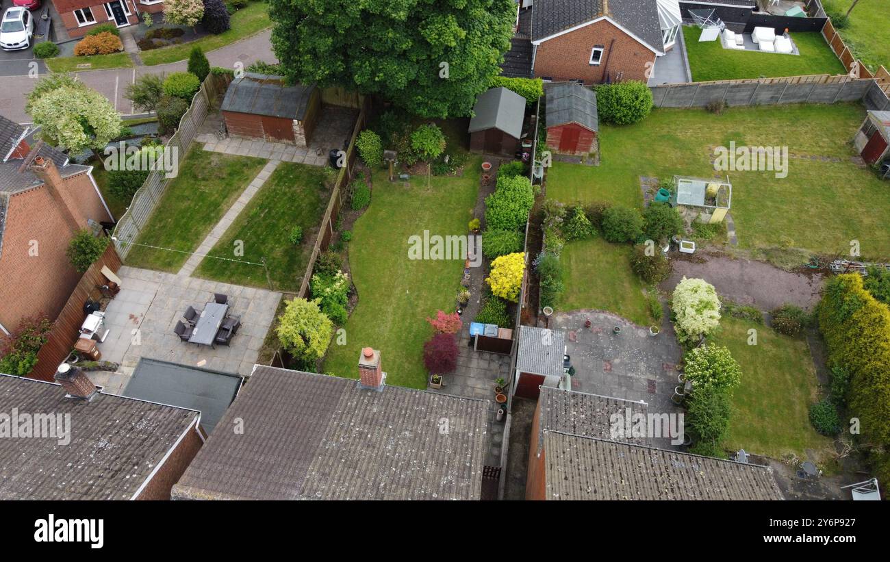 Die Wohnanlagen mit grünen Rasenflächen, Schuppen und Terrassenmöbeln in einem Vorstadtviertel. Stockfoto