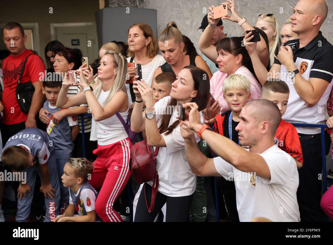 ODESSA, UKRAINE - 21. September 2024: Kinderjugendsport. Emotionale Eltern machen Fotos von den Gewinnern ihrer Kinder auf ihrem Phon Stockfoto