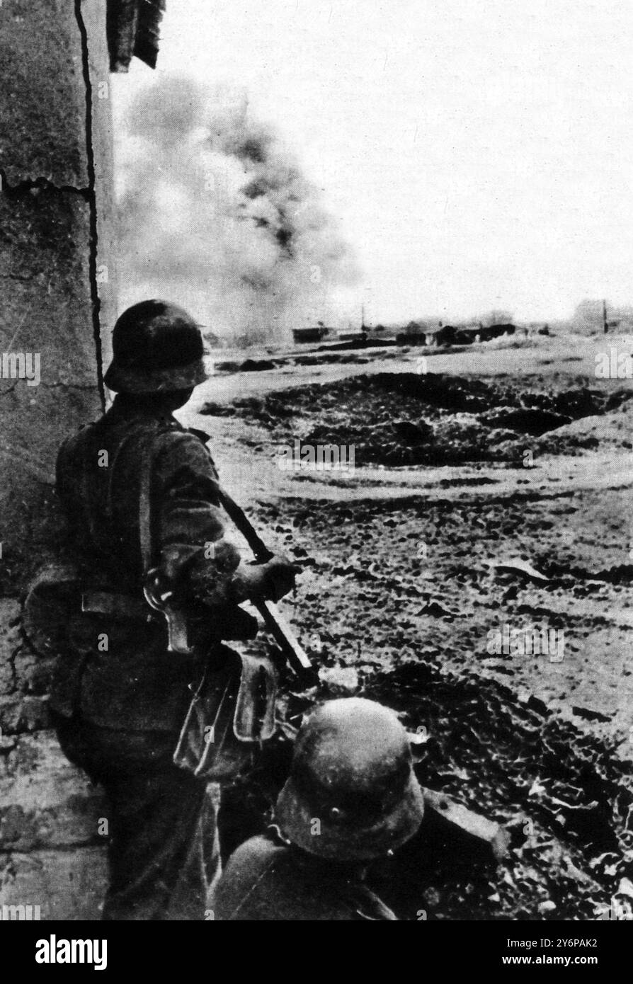 Ein Blick auf die russische Front. Am Stadtrand von Stalingrad : ein feindliches Bild deutscher Infanteristen , die darauf warten , dass ein Artilleriefach eingestellt wird , bevor er vormarschiert . 10. Oktober 1942 Stockfoto