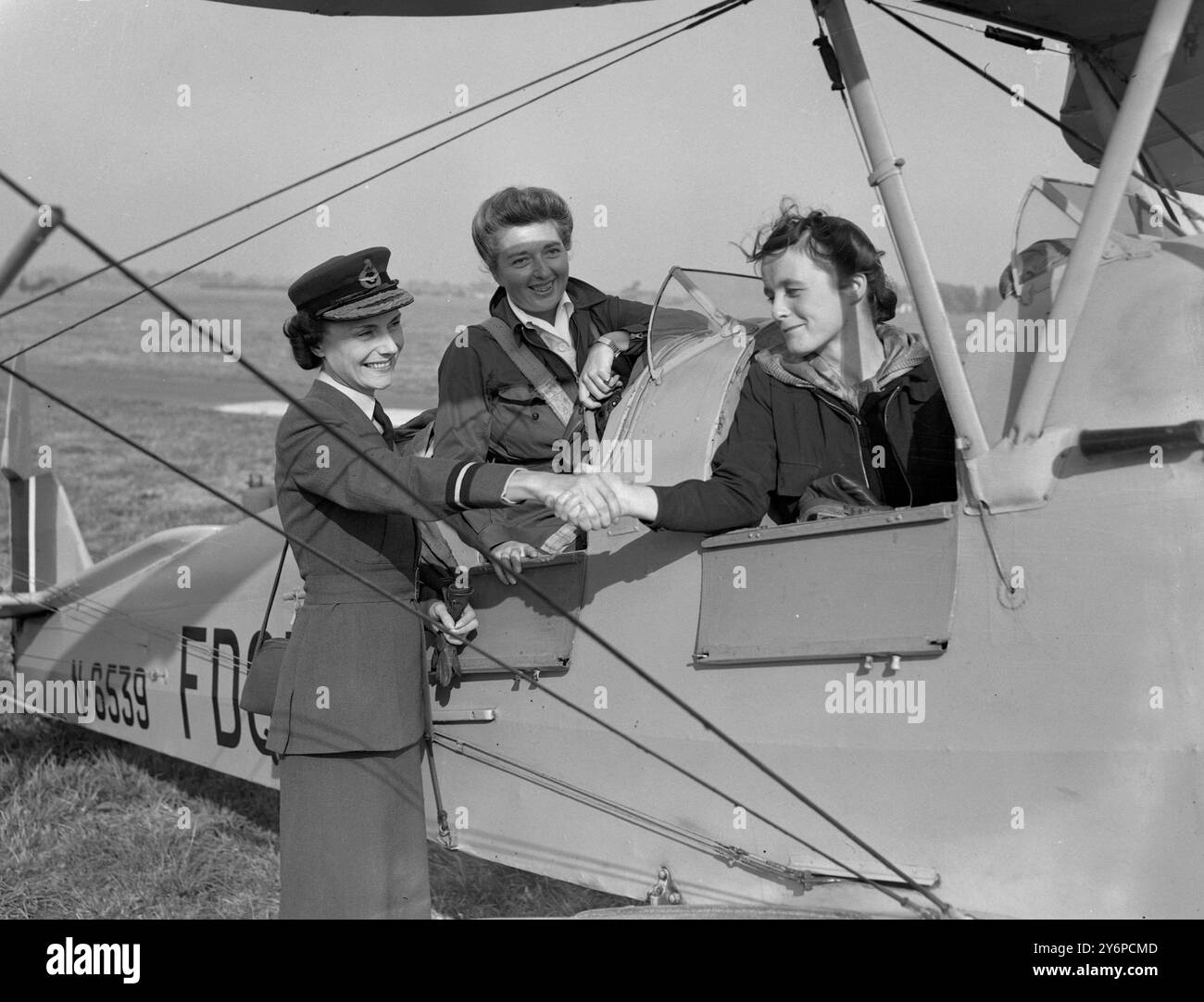 Die erste Frau, die sich der neuen WAAF-Freiwilligenfluggesellschaft angeschlossen hat , für die am 6 . Oktober 1947 die Rekrutierung eröffnet wurde , war Miss Margo Gore , die erste Frau , die einen der riesigen Amreican Flying Fortresess Bombetrs geflogen hat , die am Hauptquartier des RAF Reserve Command in White Waltham berichtet wurde . Berks , um sich anzumelden . Foto zeigt: Frau Joan Nayler , die als zweites Mädchen unterschreibt und von der Direktorin der WAAF Frau F H Hanbury, MBE, gratuliert wird, während Miss Gore im hinteren Cockpit zu sehen ist, sie war die erste, die am 6. Oktober 1947 unterschrieb Stockfoto