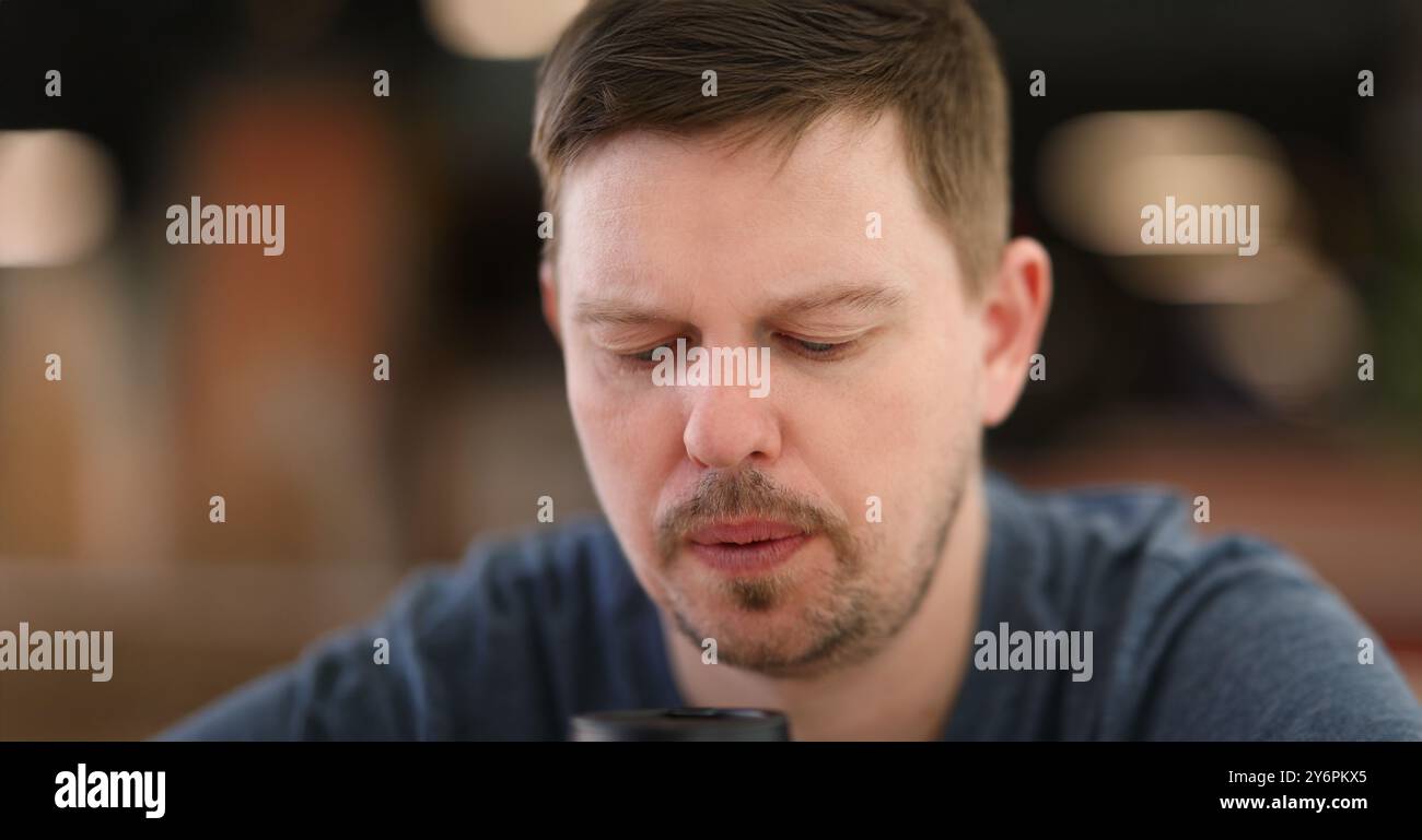 Porträt von traurig und überwältigt von etwas bärtiger Person mittleren Alters, die nach unten blickt. Verärgert und traurig unrasiertes männliches Gesicht. Nachdenklich, nachdenklich Stockfoto