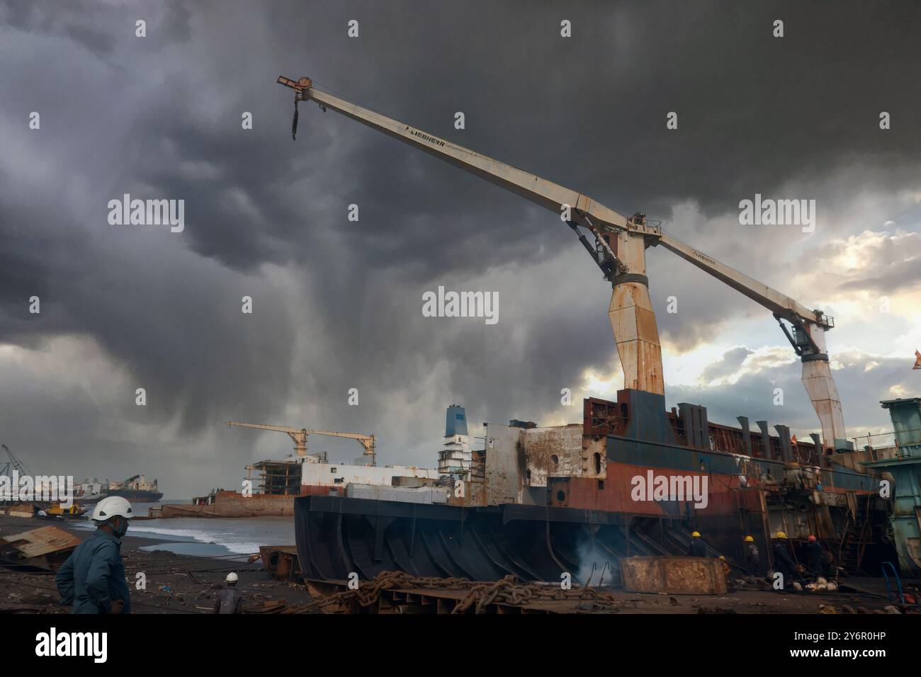 Erfassen Sie die lebendige Industrielandschaft auf der Alang Shipyard, wo stillgelegte Schiffe abgebaut werden. Diese visuelle Darstellung zeigt die Metik Stockfoto