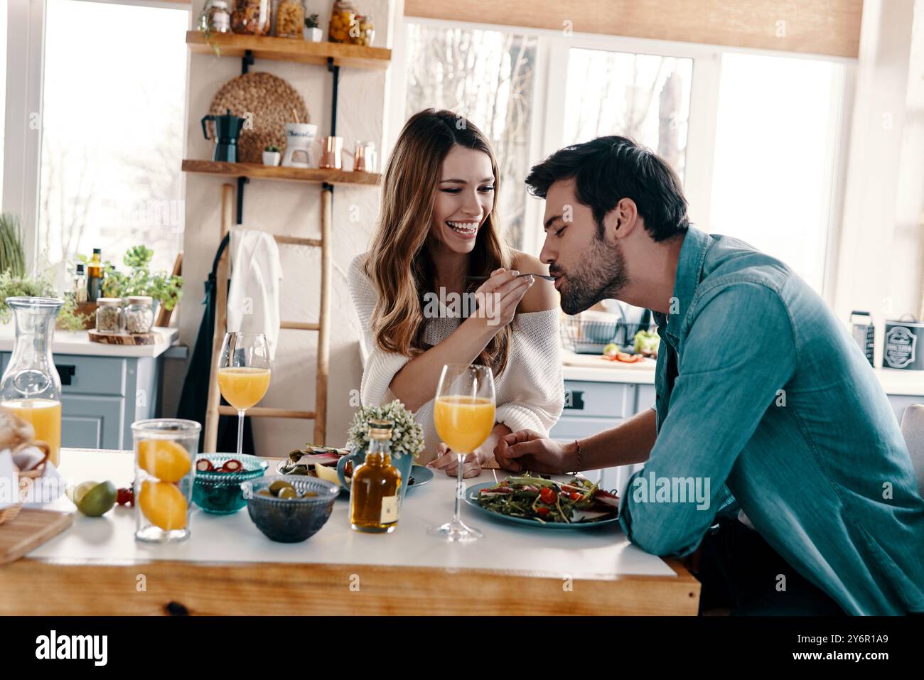 Intime Momente. Schönes junges Paar genießt gesundes Frühstück, während es in der Küche zu Hause sitzt Stockfoto