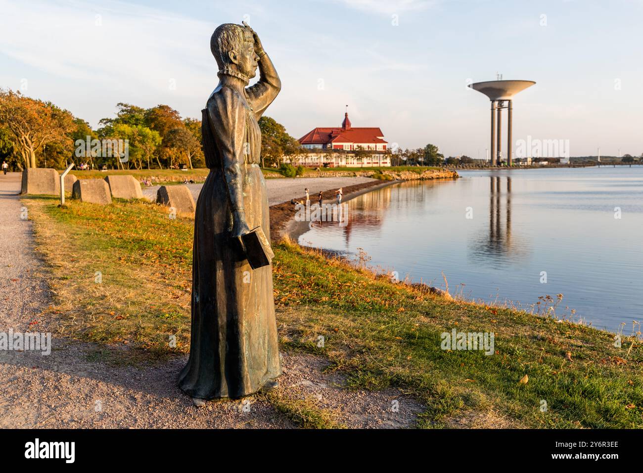 Statue der schwedischen Schriftstellerin Selma Lagerlöf (1858–1940) in Landskrona. Die Figur blickt über den Öresund und hält ein Buch in der rechten Hand. Während ihrer Zeit in Landskrona (1885 bis 1895) schrieb sie ihren ersten Roman Gösta Berling. Ihr bekanntestes Werk erschien 1907: Die wunderbare Reise des kleinen Nils Holgersson mit den Wildgänsen. 1909 gewann sie als erste Frau den Literaturnobelpreis und 1914 wurde sie als erste Frau in die Schwedische Akademie aufgenommen. Fröjdenborg, Landskrona kommun, Skåne, Schweden Stockfoto