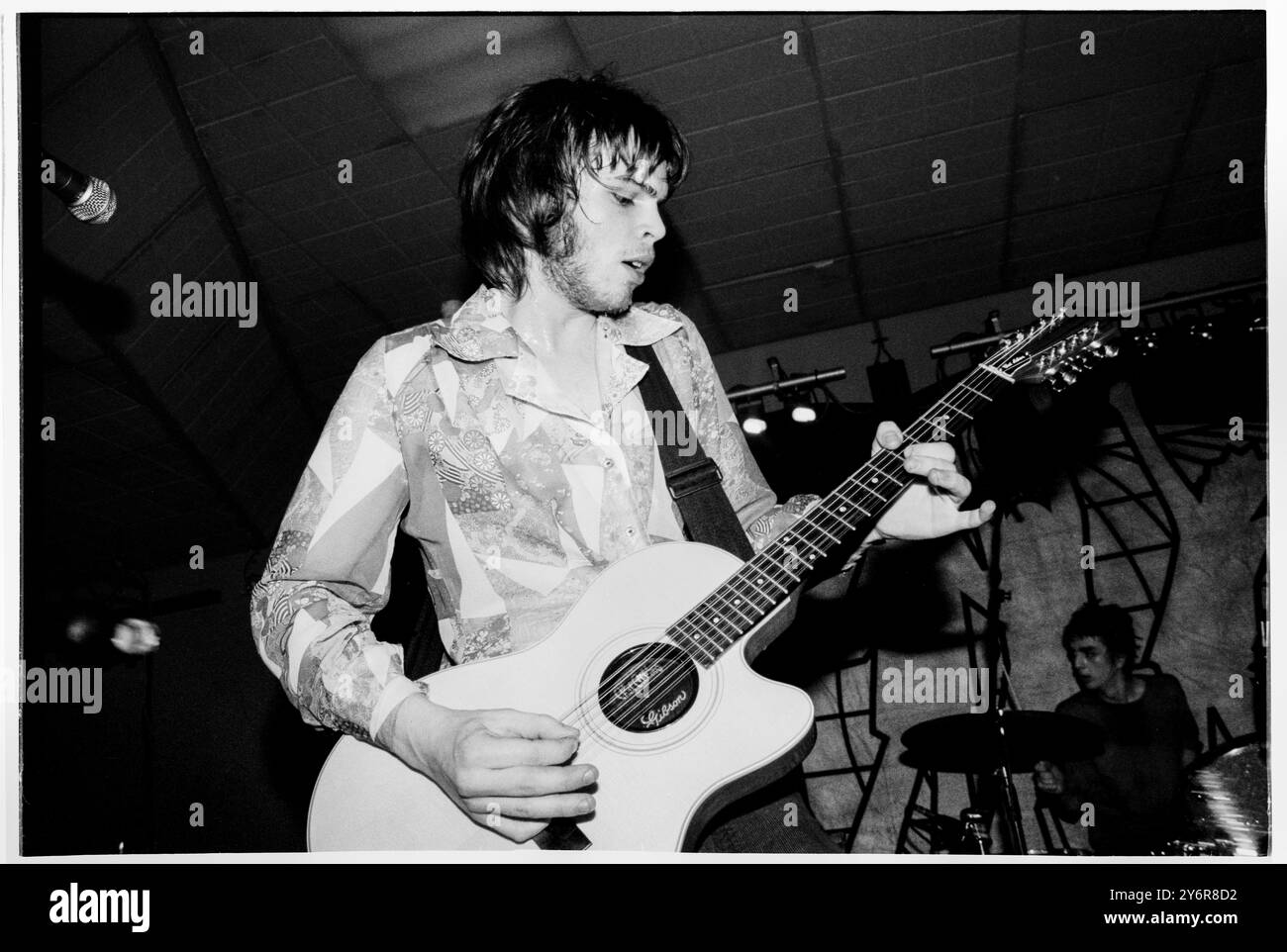 SUPERGRASS, YOUNG, EARLY TOUR, 1995: A very Young Gaz Coombes of Supergrass spielt eine Gibson 12 String Chet Atkins Gitarre an der Glamorgan University, Treforest, Wales, UK auf der ersten Headline UK Tour der Band am 7. März 1995. Foto: Rob Watkins. INFO: Supergrass, eine britische Rockband, erzielte Mitte der 1990er Jahre mit ihrer ansteckenden Mischung aus Britpop und Punkeinflüssen Erfolg. Hits wie „Alright“ und Alben wie „I Should Coco“ festigten ihren Ruf für energiegeladene, eingängige Melodien und trugen zur pulsierenden Musikszene der damaligen Zeit bei. Stockfoto