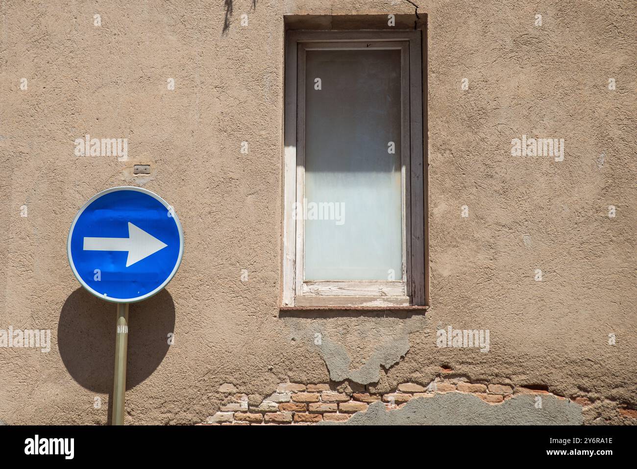 Ein Einbahnschild, das auf ein Fenster in einem Gebäude in Cambrils, Costa Dorada, Katalonien, Spanien zeigt Stockfoto