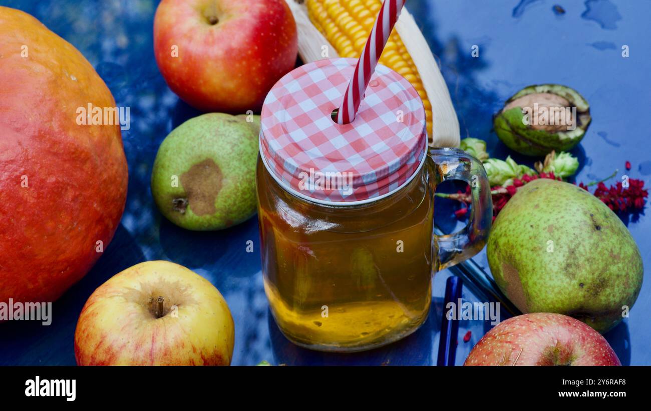 Ein Glas Apfelsaft, ein Strohhalm, Äpfel und Birnen, Stockfoto