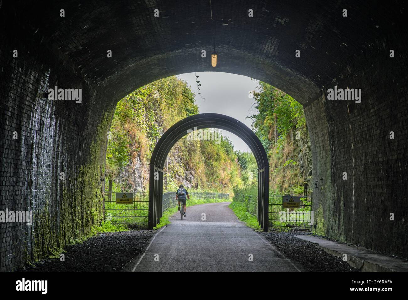 Ein Radfahrer, der den Grabstein Tunnel am Monsal Head Viaduct verlässt, Monsal Dale, Peak District, Derbyshire, England Stockfoto