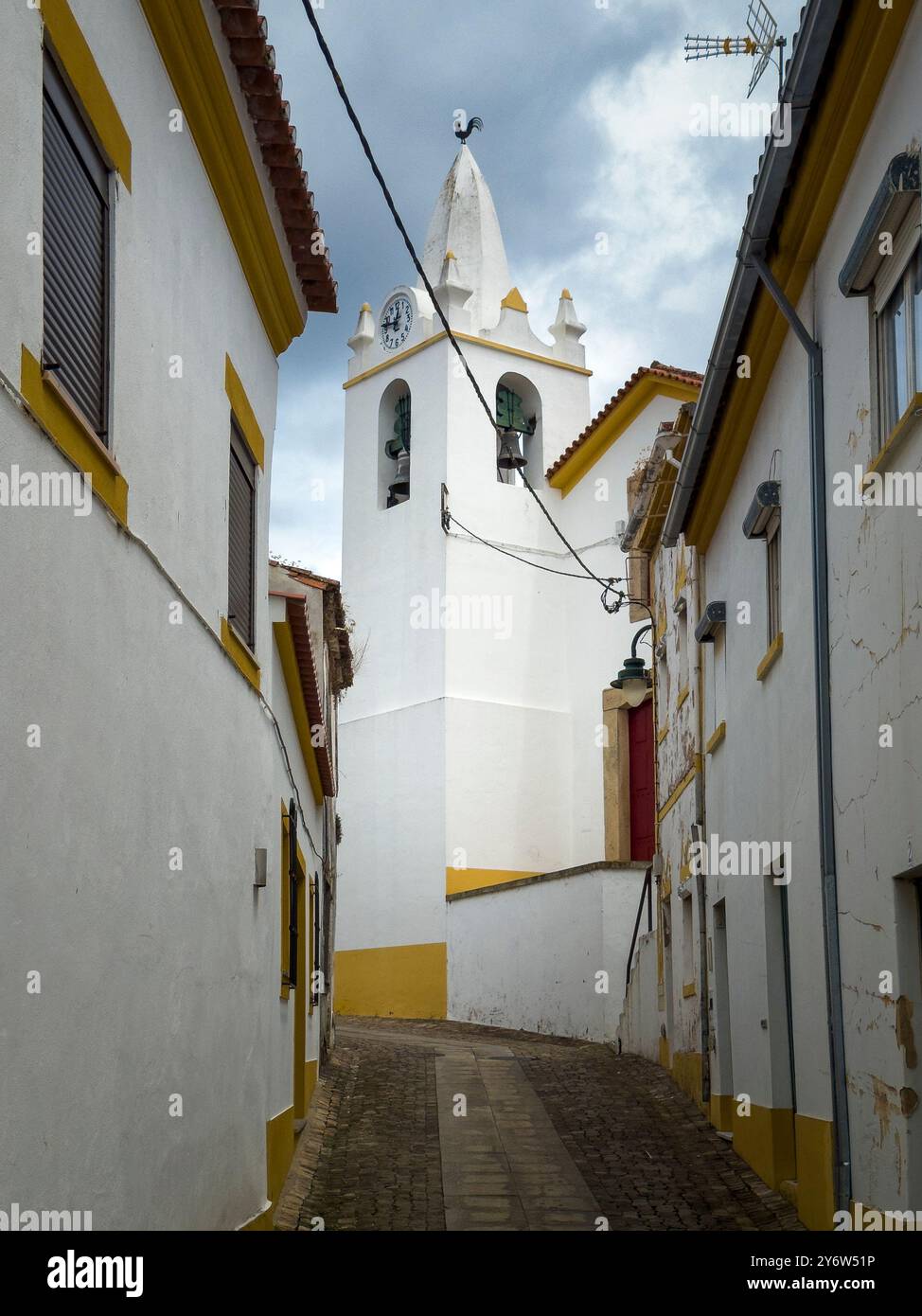Blick auf eine Straße mit traditionellen weißen und gelben Häusern im Dorf Amieira do Tejo in Alentejo, Portugal Stockfoto