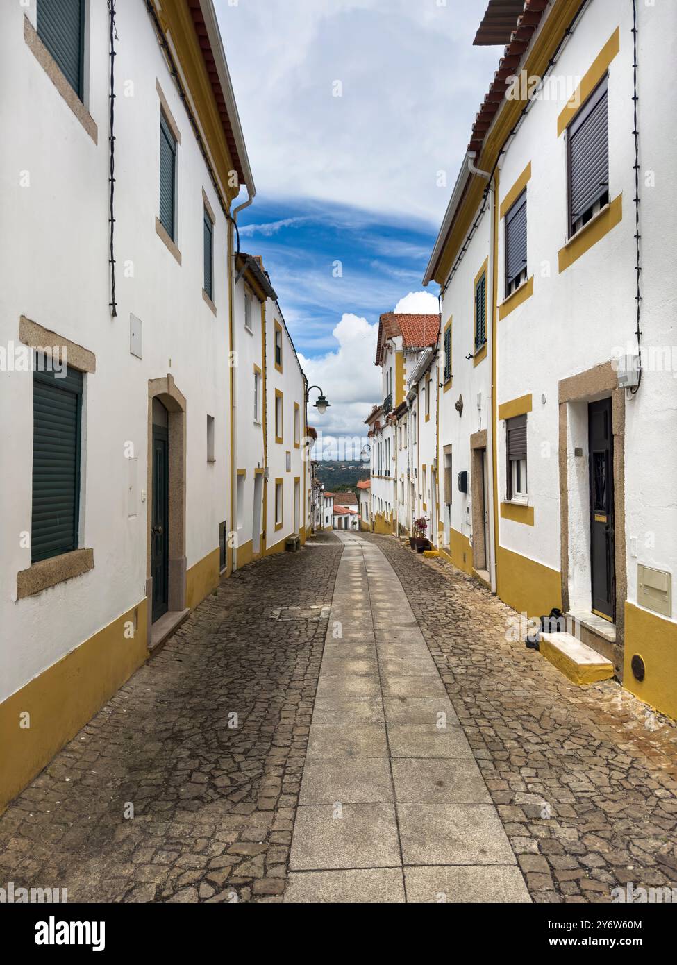 Blick auf eine Straße mit traditionellen weißen und gelben Häusern im Dorf Amieira do Tejo in Alentejo, Portugal Stockfoto