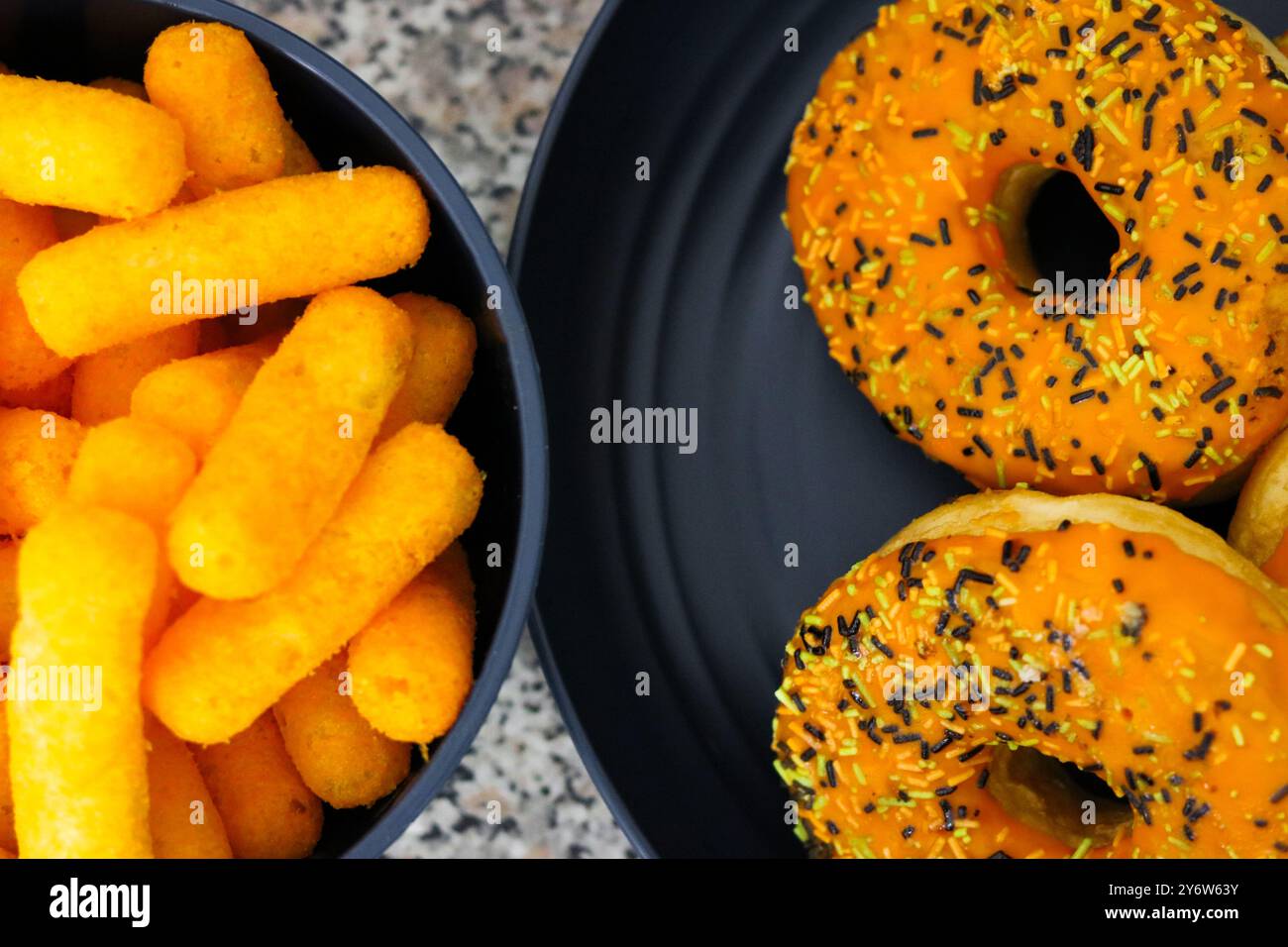 Blick von oben auf eine Schüssel mit Käse Blätterteig und Donuts Halloween Thema auf der Küchenoberseite Stockfoto