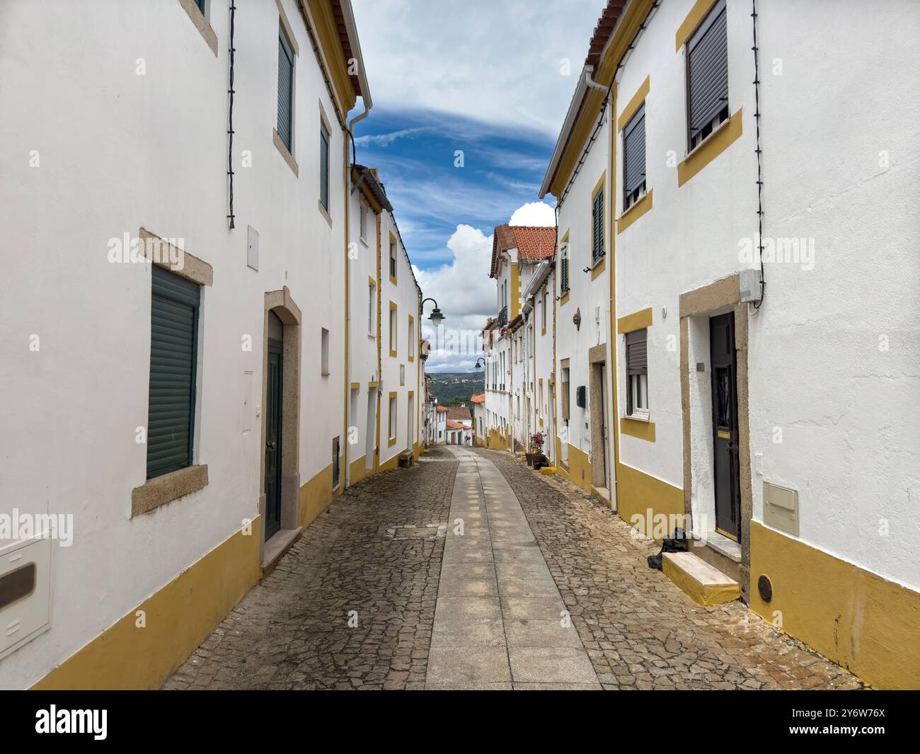 Blick auf eine Straße mit traditionellen weißen und gelben Häusern im Dorf Amieira do Tejo in Alentejo, Portugal Stockfoto