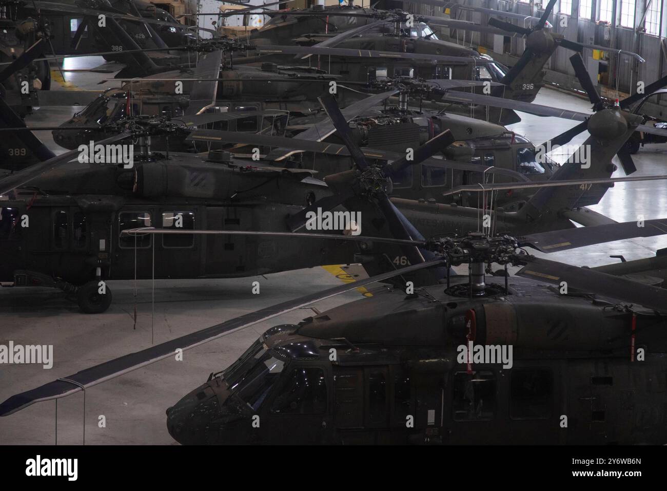 Die Hubschrauber DER US Army UH-60 Black Hawk, die der 3rd Combat Aviation Brigade (CAB), 3rd Infantry Division, zugeordnet sind, sind dicht in einen Hangar gepackt, um die Hubschrauber vor den Auswirkungen des Hurrikans Helene auf dem Hunter Army Airfield, Georgia, 26. September 2024 zu schützen. Um eine genaue Geräteeinsatzbereitschaft zu gewährleisten, führte die 3. KABINE schnell dichte Packoperationen durch, die die Sicherheit der Soldaten gewährleisten. Stockfoto