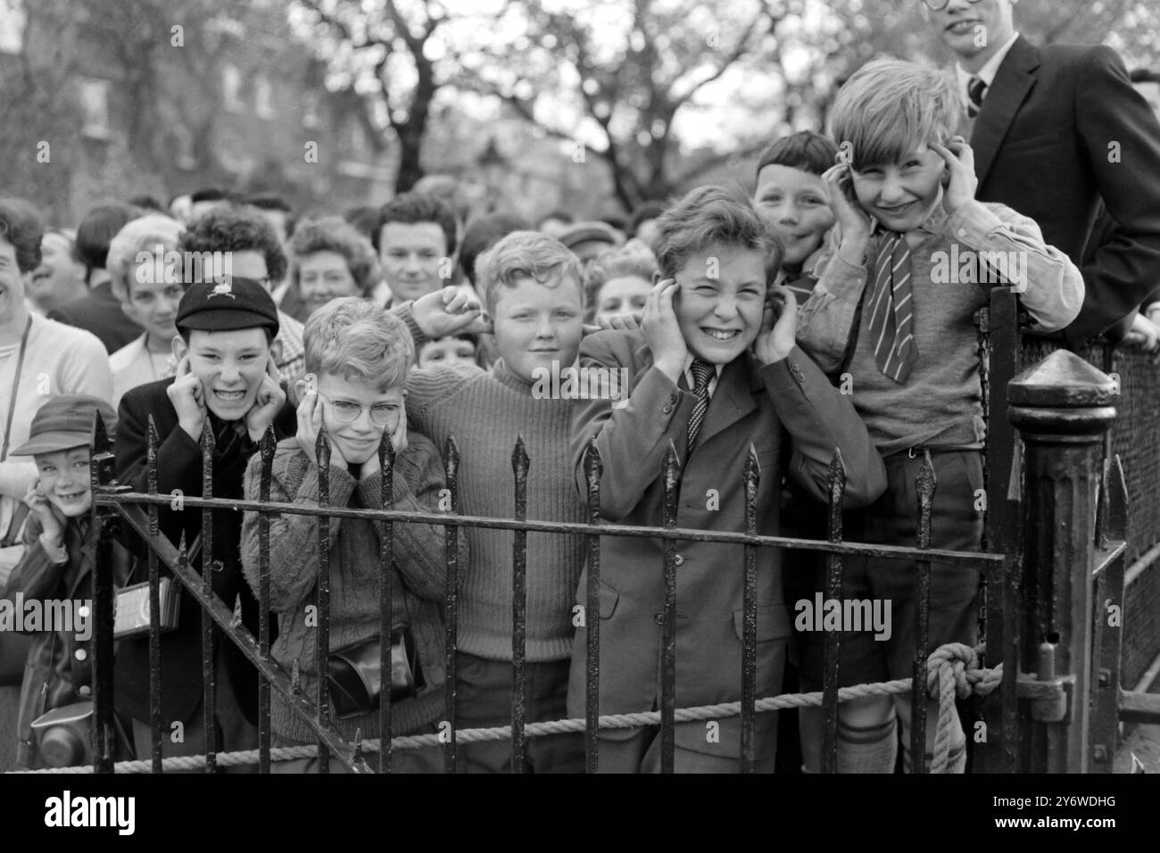 AM 21. APRIL 1961 VERSPERREN SICH DIE KINDER WÄHREND EINES KÖNIGLICHEN WAFFENGRUSSES ZU EHREN DES 35. GEBURTSTAGS VON KÖNIGIN ELIZABETH II. TOWER BRIDGE, LONDON, ENGLAND. Stockfoto