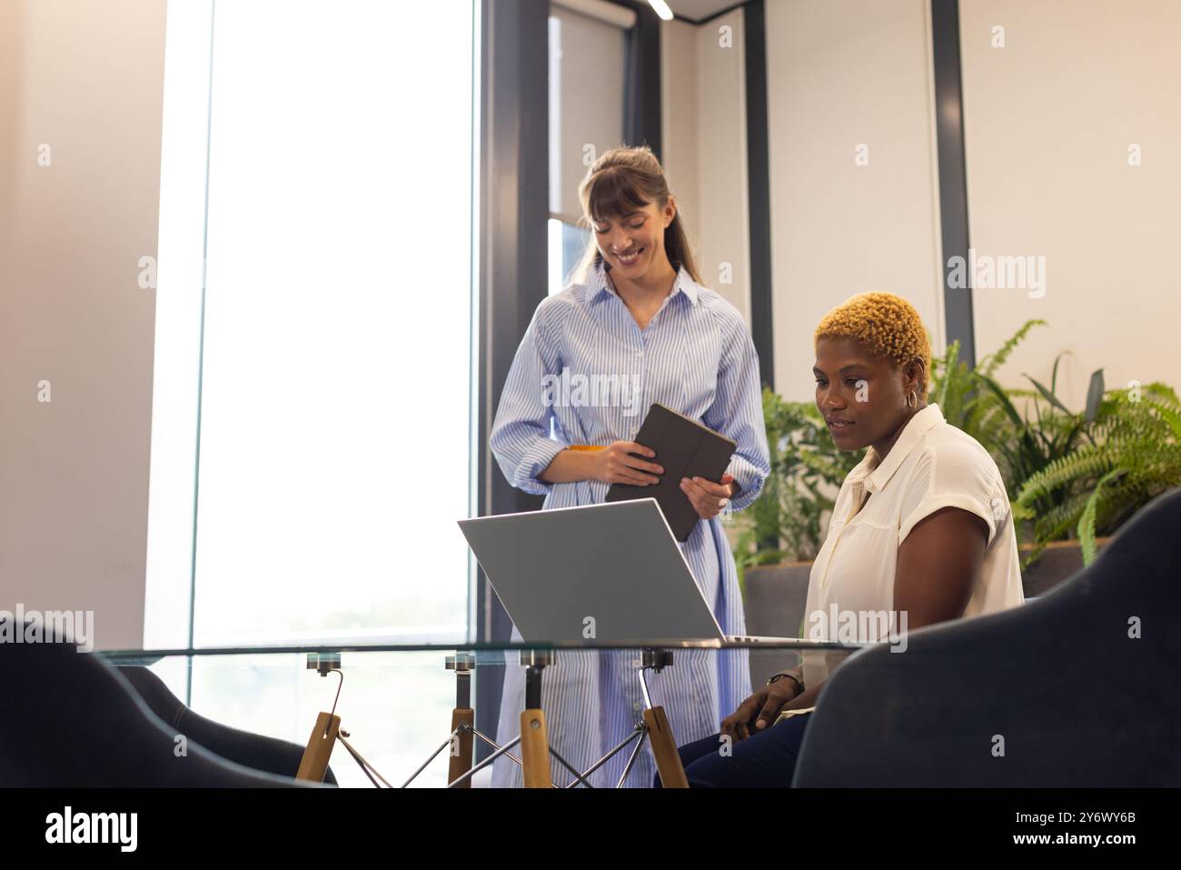 Zusammenarbeit im Büro, zwei Frauen verwenden Laptop und digitales Tablet am Schreibtisch Stockfoto