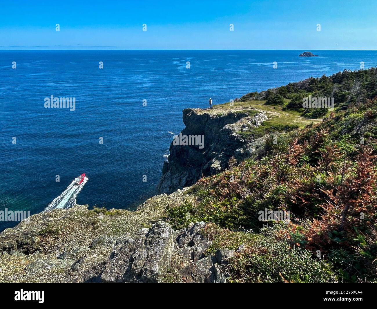 Der Mensch steht allein am Rande einer steilen Klippe und überblickt den Atlantischen Ozean. Stockfoto