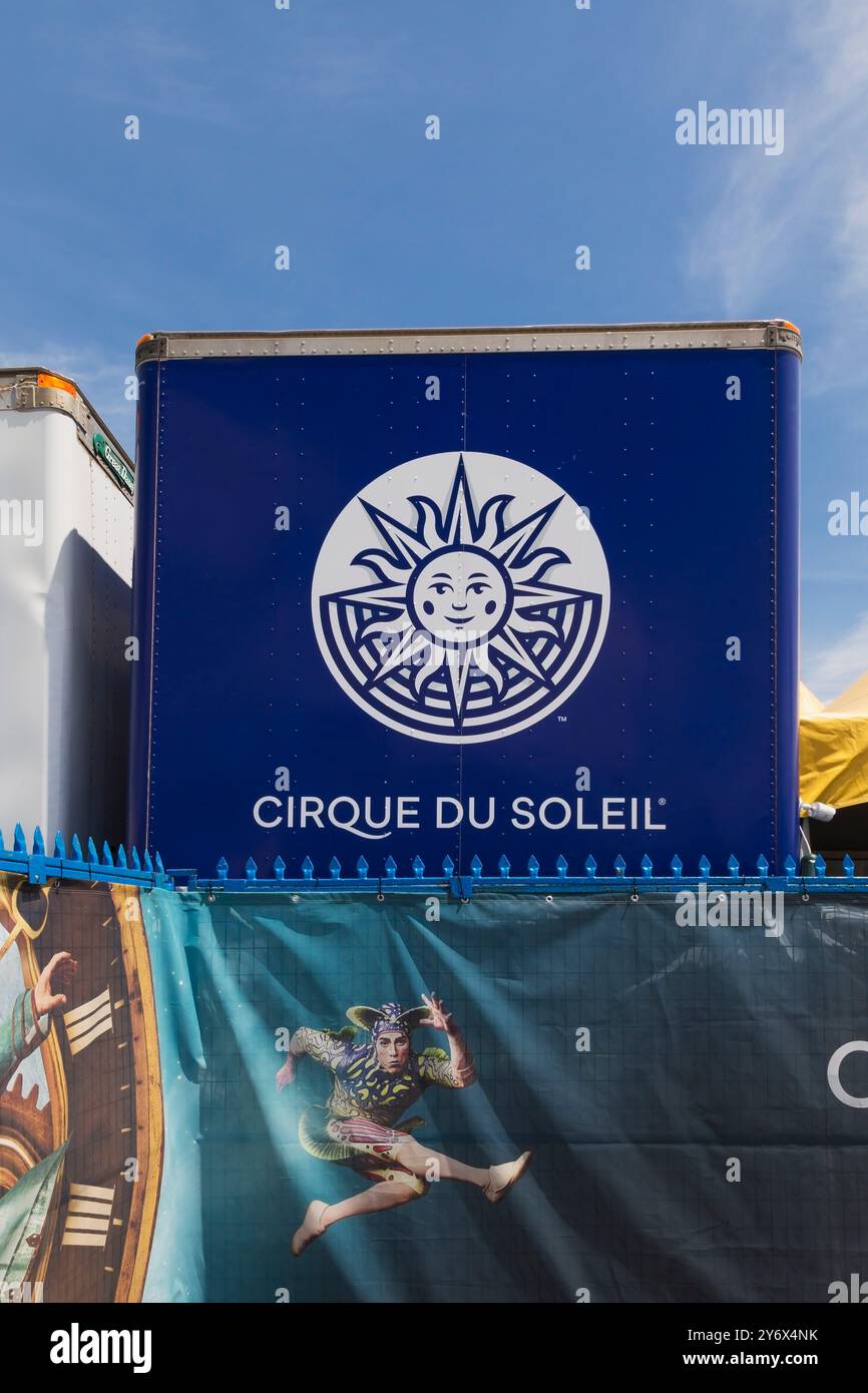Das Logo des Cirque du Soleil und die Illustration auf dem Lager- und Versandbehälter sowie das Werbebanner „Kurios“ auf dem Zaun der Installation eines großen Zeltes zeigen. Stockfoto