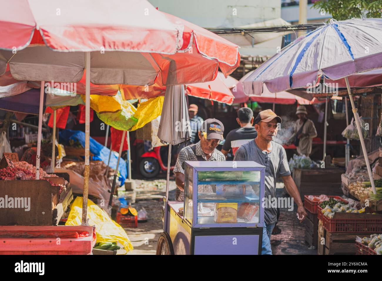 Balikpapan, Indonesien - 26. Juni 2024. Der alte Eisverkäufer verkauft an einem sonnigen Tag Eisbrot und Eiskegel. Stockfoto