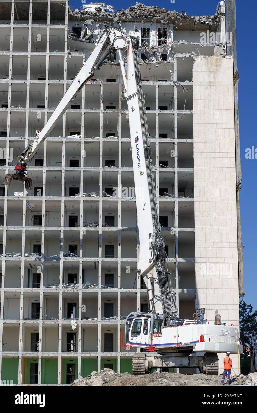Blick auf einen weißen Raupenbagger Liebherr R 974 C, der einen Bürokomplex abriss. Stockfoto