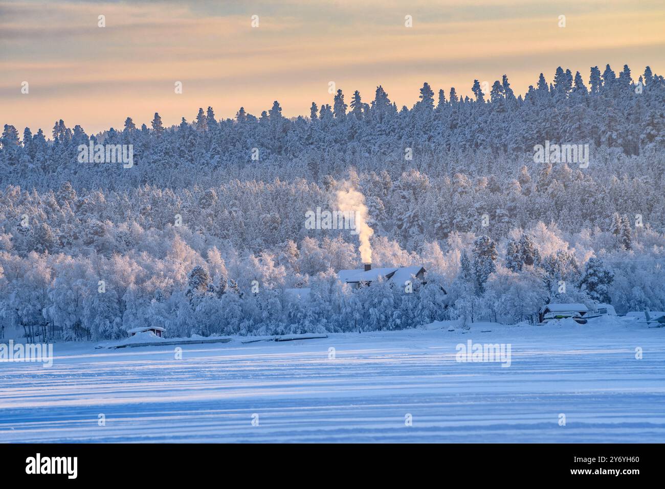 Gefrorener und schneebedeckter Inari-See im Winter, bei Sonnenuntergang (Lappland, Finnland) ESP: Lago Inari helado y nevado en invierno, visto al atardecer (Laponia) Stockfoto