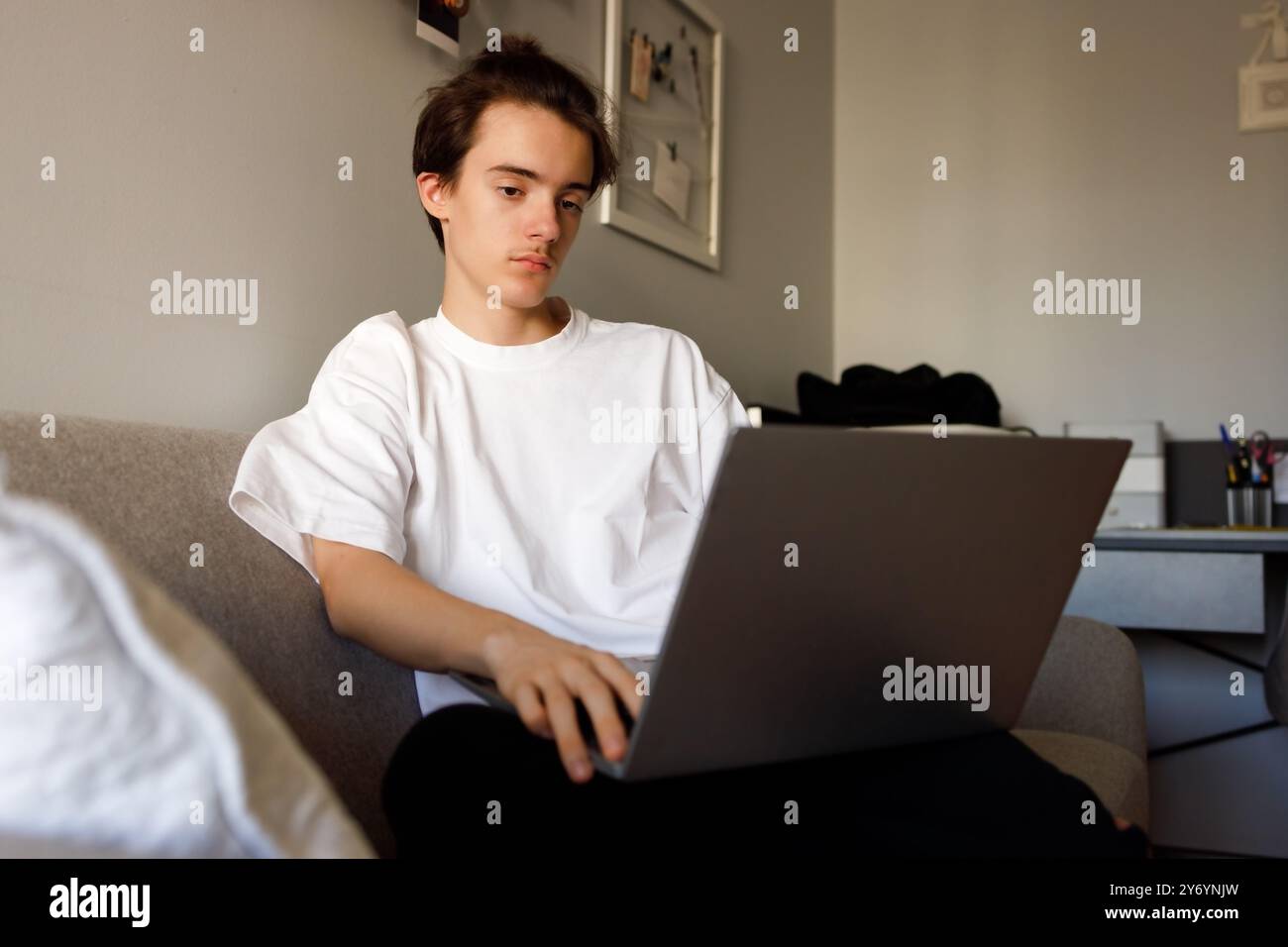 Junge Menschen, die sich bei der Arbeit am Notebook zu Hause konzentrieren Stockfoto