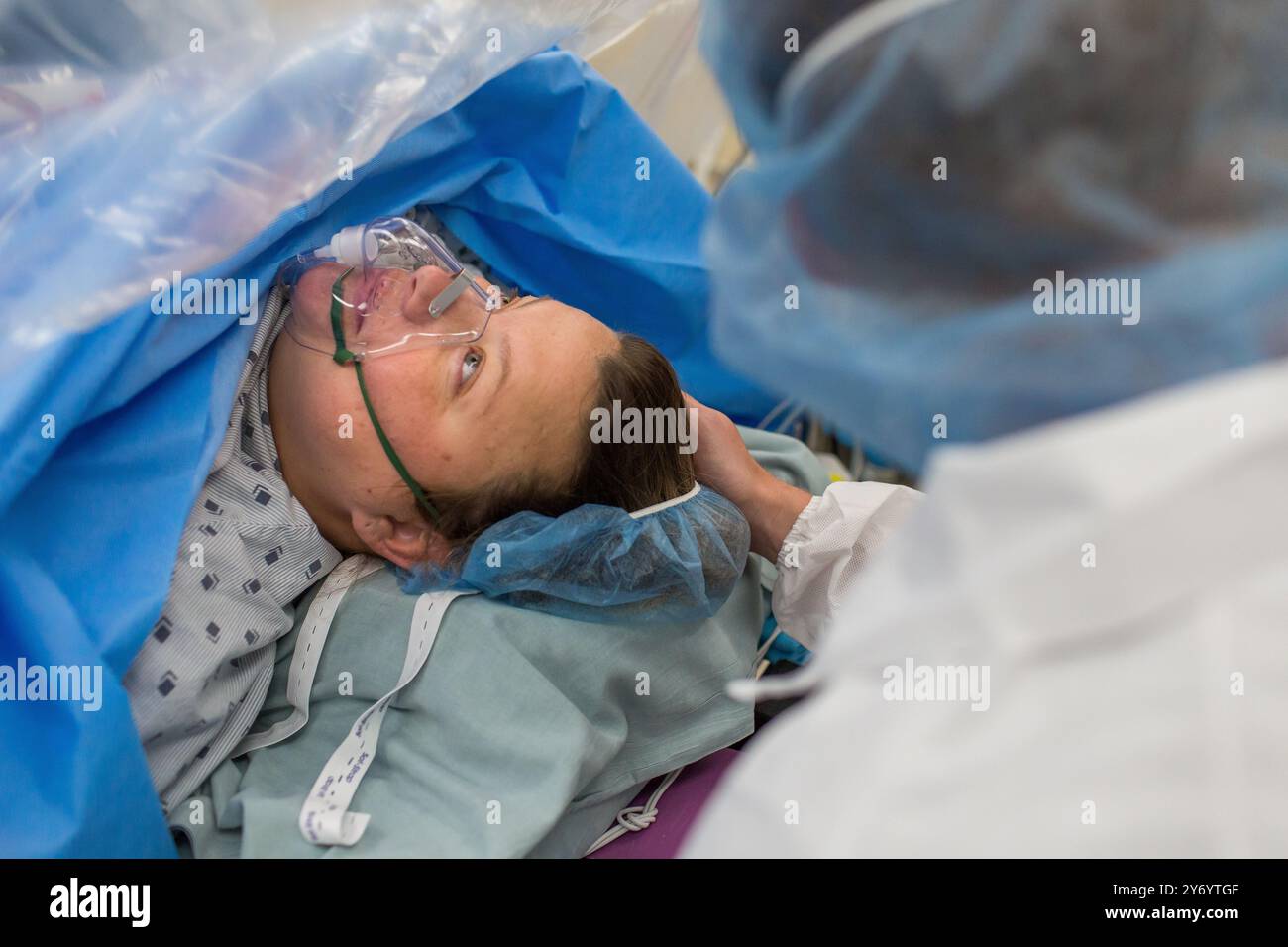 Dad streichelt Moms Haar, während sie auf C-Sektion wartet Stockfoto