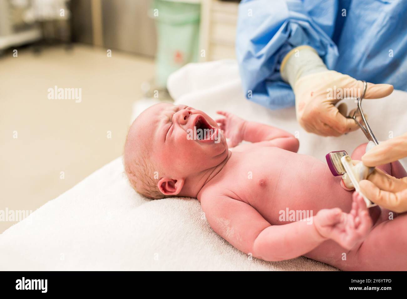 Schwester, die Nabelschnur im Operationssaal beim Neugeborenen schneidet Stockfoto