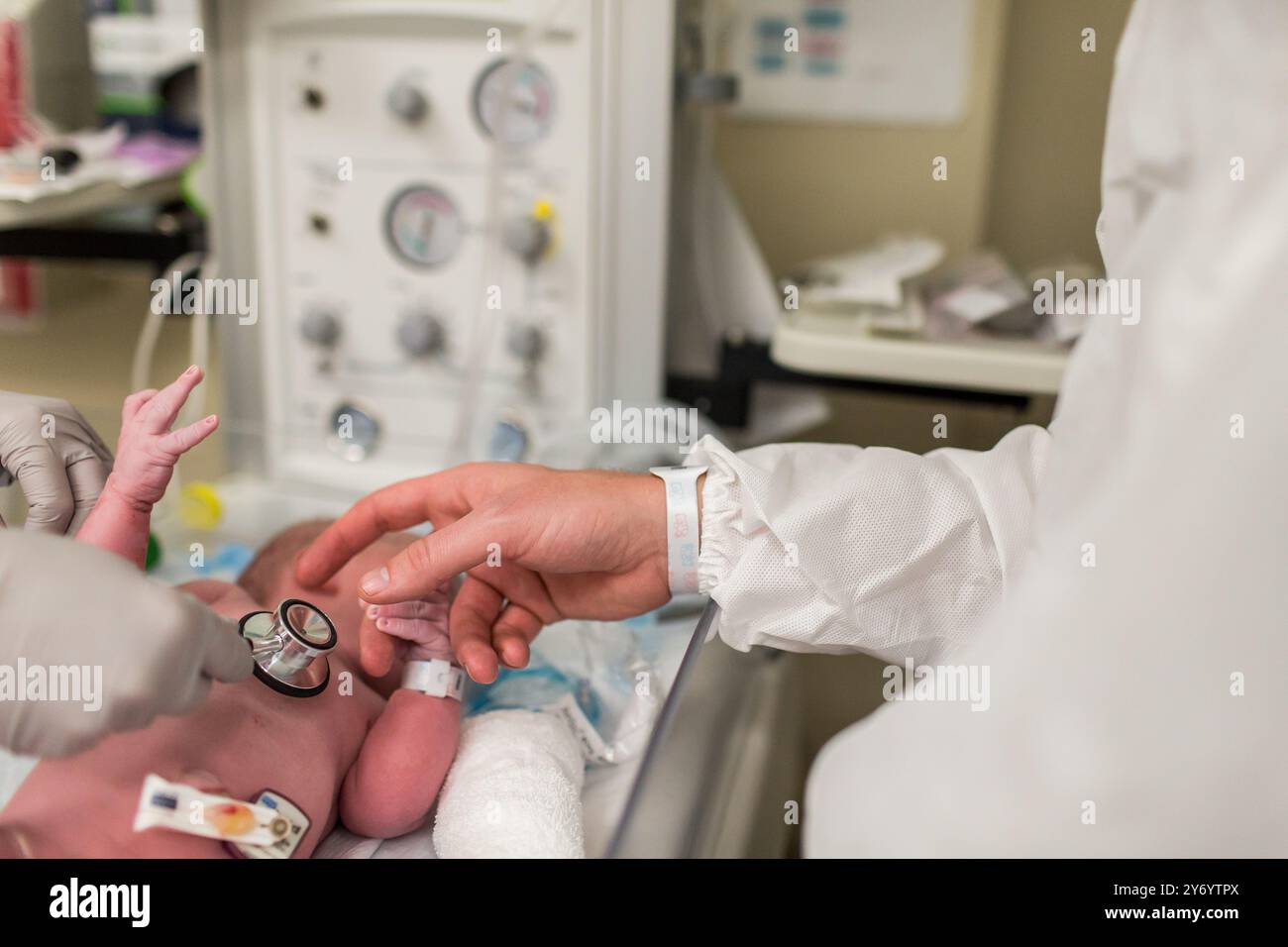 Neugeborenes Kind wird nach dem C-Schnitt mit Stethoskop untersucht Stockfoto