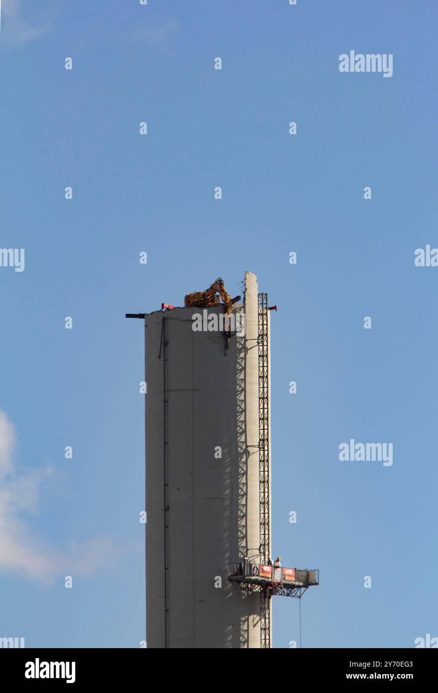 Bochum, Rückbau des Opelwerks. 25.06.2015, EU, DEU, Deutschland, Nordrhein-Wstfalen, Bochum: Strukturwandel im Ruhrgebiet. Abrissarbeiten am ehemaligen Opelwerk. Ein ferngesteuerter Bagger reist den fast 100 Meter hoher Schornstein der Opel-Lackiererei im Werk 1 an der Wittener Straße ab. EU, DEU, Deutschland, Nordrhein-Westfalen, Bochum: Strukturwandel im Ruhrgebiet. Abbrucharbeiten im ehemaligen Opel-Werk. Ein ferngesteuerter Bagger zerstört den fast 100 Meter hohen Schornstein der Opel Lackiererei im Werk 1 an der Wittener Straße. Stockfoto