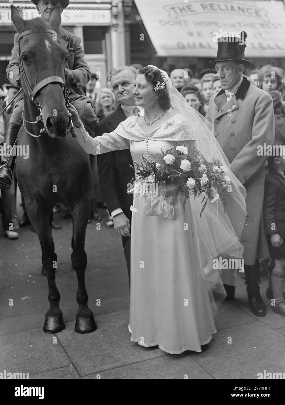 PFERD ALS HOCHZEITSGAST Ein Pferd ging zur Hochzeit von Frau ANNA SHARLINSKI aus der Woodquest Avenue, Herne Hill, S.E. Miss Sharlinski war mit Herrn verheiratet . James Powell von Mount Ephraim Lane. Streatham, S.W., in St . Anne's Roman Catholic Church , Kennington Lane , London . Das Pferd war Dolly eine 30-jährige, preisgekrönte Stute , die , so die Braut , an allem teilgenommen hat , was in der Familie passiert ist , seit sie sich erinnern kann . Nach der Zeremonie begleitete Dolly mit einem Outtrider den Brautwagen zum Empfang in Westminster . DAS BILD ZEIGT: Die Braut empfängt die Puppe Stockfoto