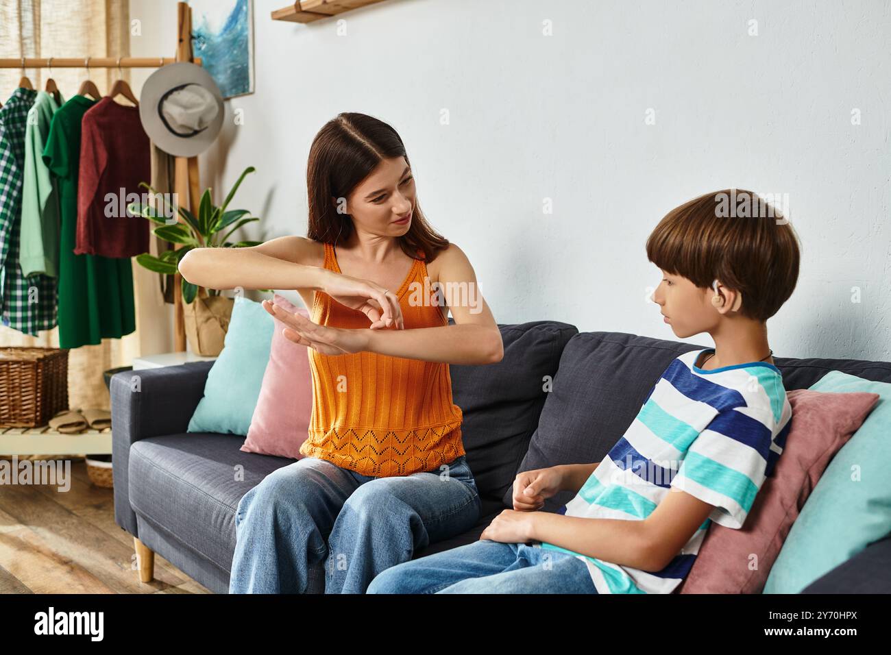 Eine fürsorgliche Mutter verwickelt ihren Sohn mit Hörstörungen in unterstützendes Lernen zu Hause. Stockfoto