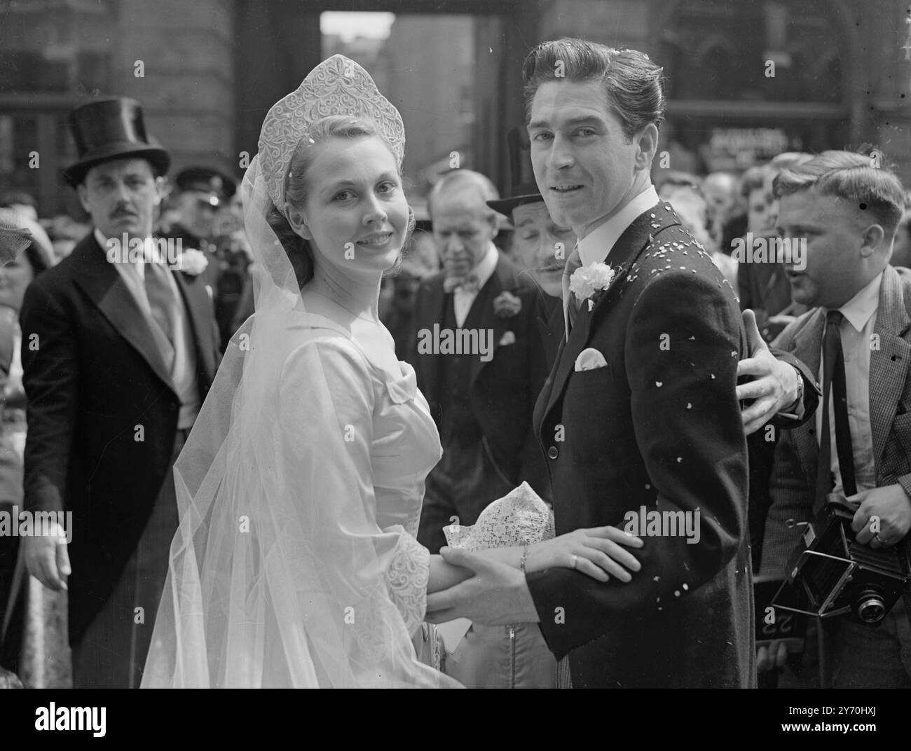 DIE 23-jährige Filmschauspielerin Hazel Court und ihr Bräutigam Dermot Walsh verlassen heute nach ihrer Hochzeit die St. James's Church, Spanish Place, London. Mr. Walsh und Miss Court waren in dem Stück "Random Harvest" auf Tournee. Das Hochzeitskleid der Braut ist aus reinem weißem Satin mit mittelalterlichem Gürtel und hochgedrehten Bündchen, die mit weißen und roten Stickereien mit Gold verziert sind. Juli 1949 Stockfoto