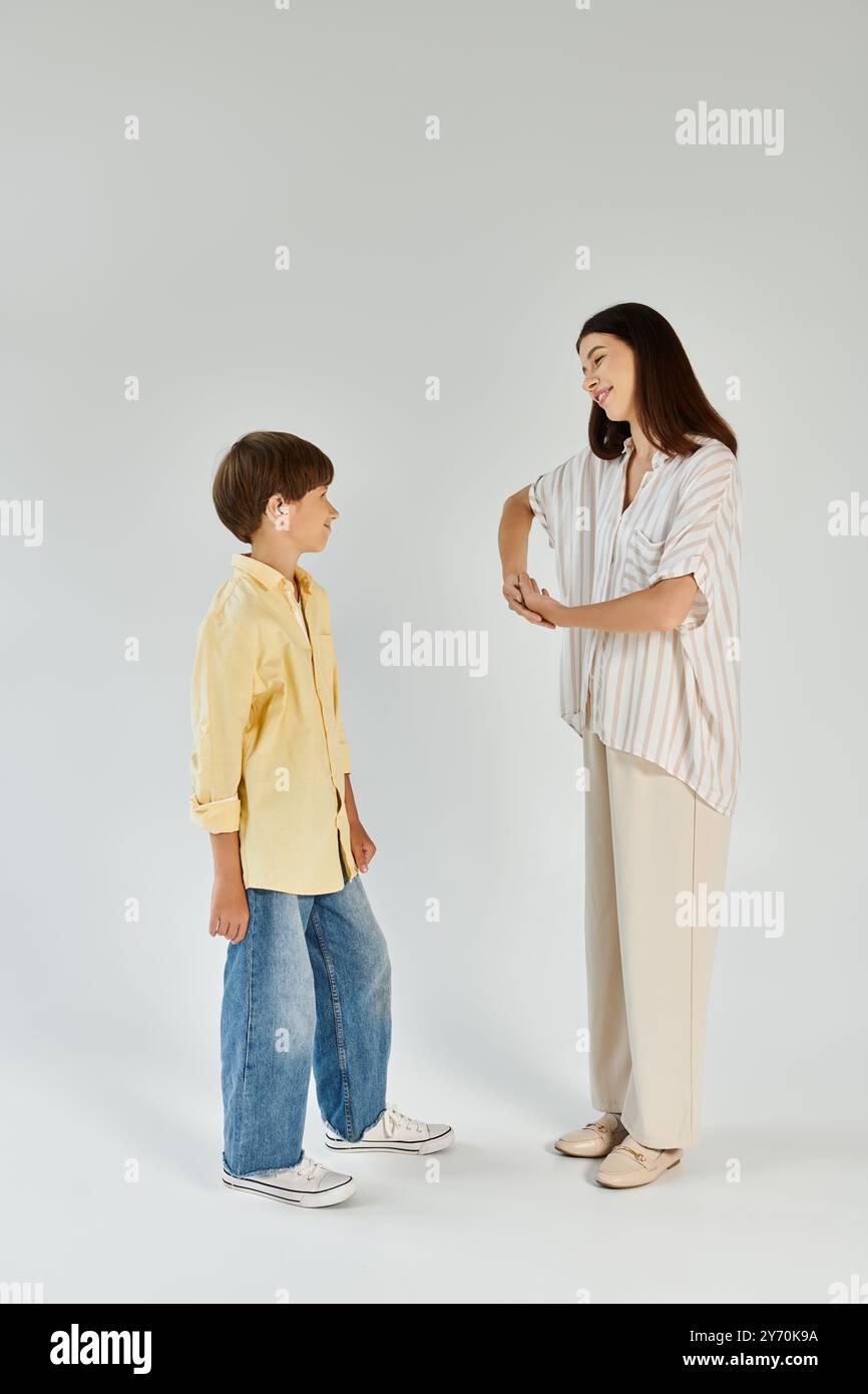 Eine pflegende Mutter kommuniziert geduldig mit ihrem hörgeschädigten Sohn in Gebärdensprache. Stockfoto