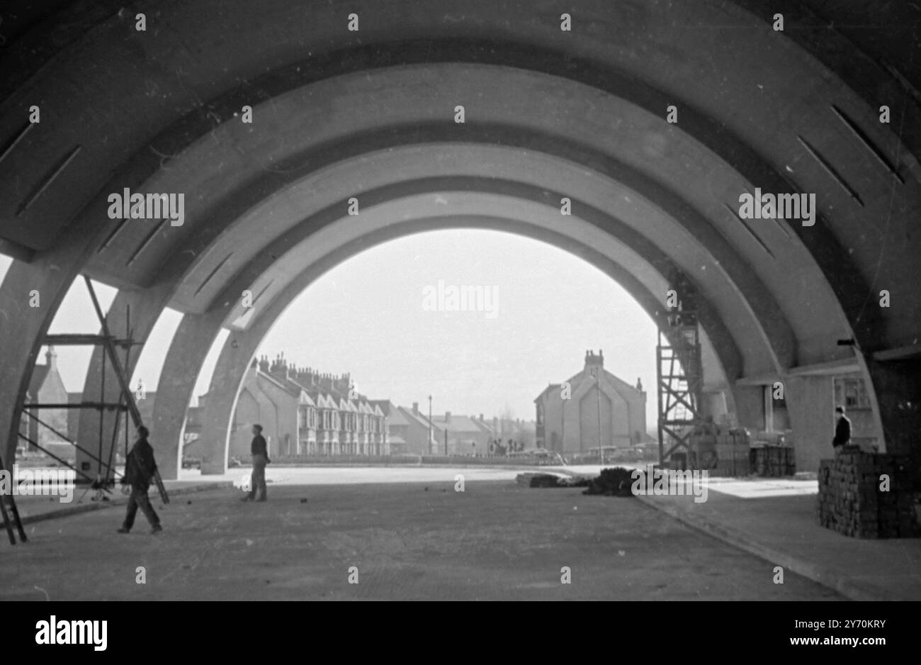 ETWAS NEUES AN BUSBAHNHÖFEN dieses Bild zeigt das einzigartige Design einer neuen London Transport Bus Station am Newbury Park . Er ähnelt einem Flugzeughangar und besteht aus sieben halbkreisförmigen Betonbögen , die mit Betonplatten überdacht sind , die mit Kupfer ummantelt sind . Der Bahnhof , der in Kürze gekoppelt wird , ist mit der Buchungshalle der Central Line und den Bahnsteigen über einen überdachten Weg verbunden . 18. April 1949 Stockfoto