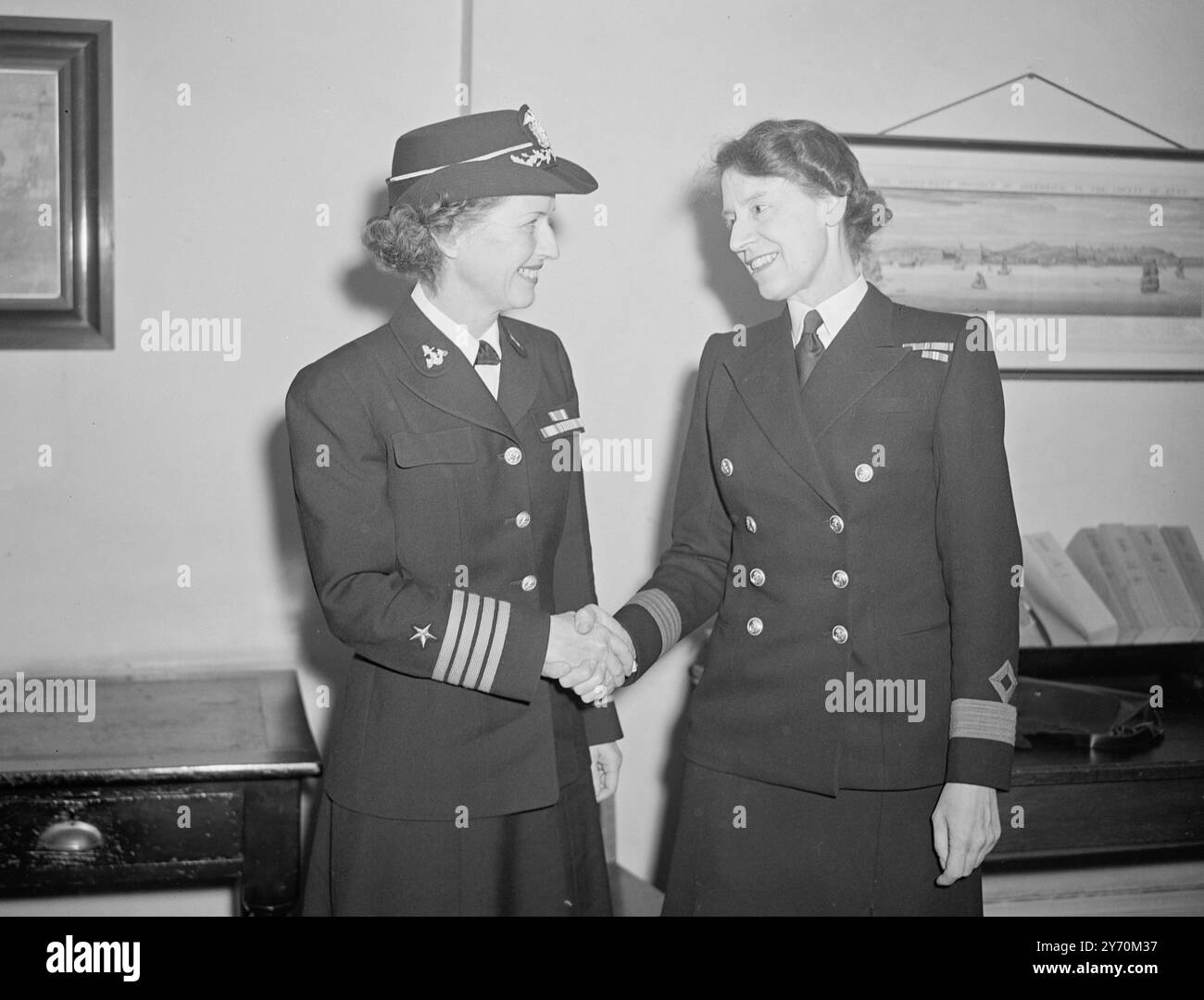 HÄNDE ÜBER DEN ATLANTIK Cordial Handschlag, als Miss JOCELYN WOOLCOMBE, Direktorin des britischen Royal Naval Service, ihre amerikanische „Gegenzahl“ begrüßt - Captain JOY BRIGHT HANCOCK, Chief of the WAVES, US-Äquivalent der W.R.N.S. - in Queen Anne's Mansion, London. Captain Hancock, der links auf dem Bild steht, ist hier, um britische Marineeinrichtungen zu besuchen und sich mit W.R.N.S. auszutauschen, wie Miss Woolcombe. Sie ist 50 Jahre alt und diente im Ersten Weltkrieg. Es wird angenommen, dass Captain Hancock einige ihrer Mädchen veranlasst, Aufgaben im Londoner Hauptquartier zu übernehmen Stockfoto