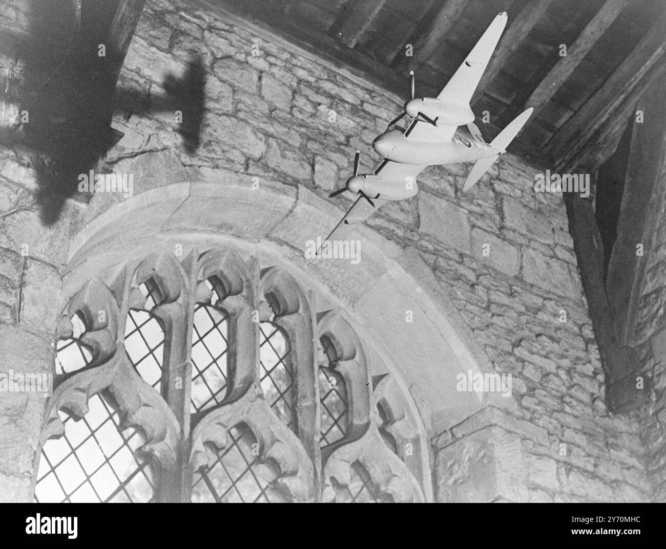 MÜCKENMODELL IN DER KIRCHE aus dem 14. JAHRHUNDERT: AIRMEN's MEMORIAL Ein detailliertes Modell eines Mückenflugzeugs hängt in der Memorial Chapel der Luftwaffe, die in der Pfarrkirche aus dem 14. Jahrhundert in Cottesmore, Rutland, geweiht werden soll. Die Kirche ist weniger als eine Meile (1,6 km) von der Station Cottesmore Royal Air Force entfernt, von der aus britische und amerikanische Kampfflugzeuge während des Zweiten Weltkriegs betrieben wurden. Über 200 Männer aus Cottesmore kamen ums Leben. Die Idee für die Kapelle, die sowohl an britische als auch an amerikanische Luftstreitkräfte erinnert, stammt von der Schwester eines jungen Architekten, der in Cottesmore getötet wurde. Berühmt Stockfoto