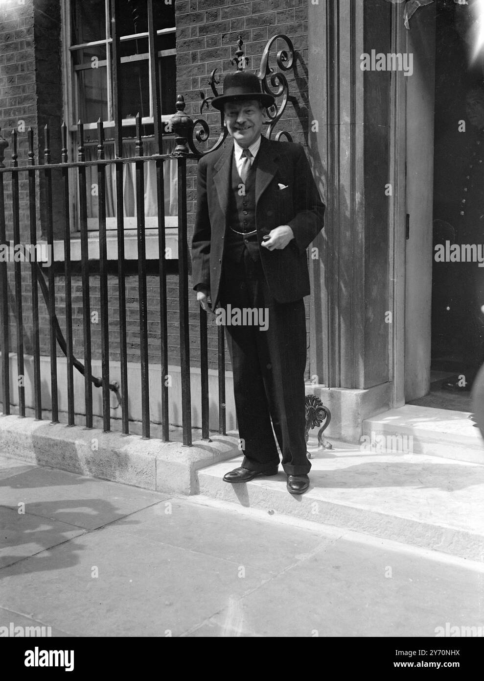 EMERGENCY PREMIER NIMMT KINGS BOTSCHAFT AN DAS UNTERHAUS Mr. Clement Attlee, der Premierminister, schafft es, trotz der Ernsthaftigkeit der Situation ermutigend zu lächeln, als er heute die Nummer 10, Downing Street, London verlässt, um im Unterhaus den Ausnahmezustand zu verkünden, nachdem die Docker beschlossen hatten, die Stilllegung in den Londoner Docks nicht zu beenden. Die Ankündigung erfolgte in Form einer Botschaft an den Sprecher des Königs, der die Proklamation auf Anraten des Geheimrats unterzeichnet hatte. Juli 1949 Stockfoto