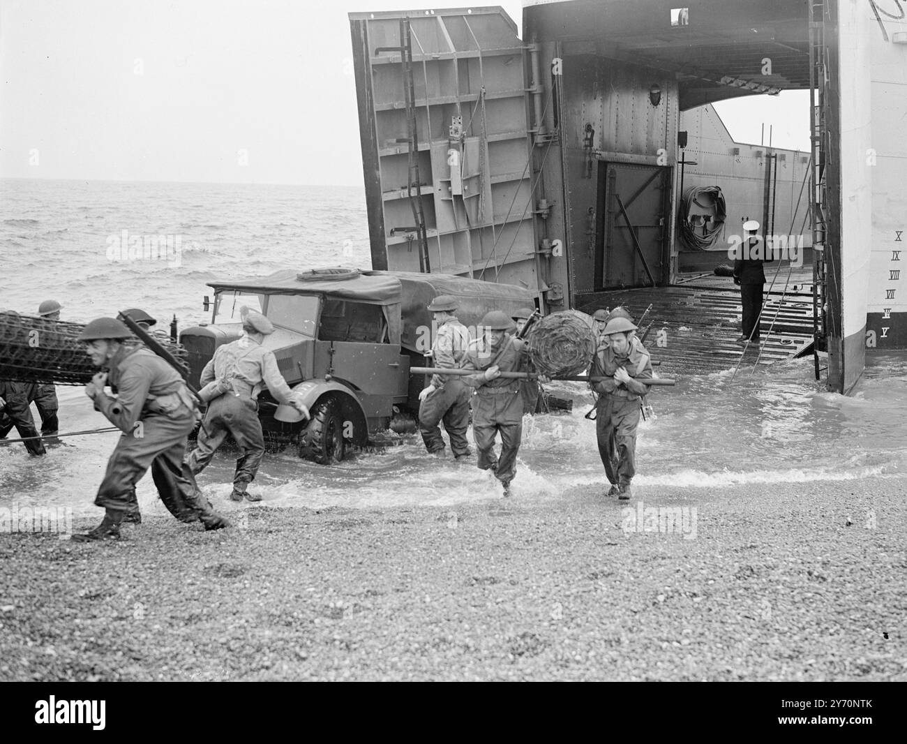 Eine der größten Übungen der Royal Engineers der Territorialarmee fand in Landguard Point , Felixstowe , Suffolk statt . Territorials von 25 Ingenieuren der Gruppe T.A., die vom Personal der Royal Navy der Combined Operations bemannt wurden, stiegen von Landungsbooten aus und räumten einen Weg durch ein Strandminenfeld frei , um Fahrzeuge ( einschließlich eines Bulldozers ) zu landen . Minen aller Art ( britisch deutsch und italienisch ) mussten behandelt werden . Obwohl die Minen harmlos waren, wurden kleine Sprengstoffladungen elektrisch detoniert, um den Realismus zu erhöhen Stockfoto
