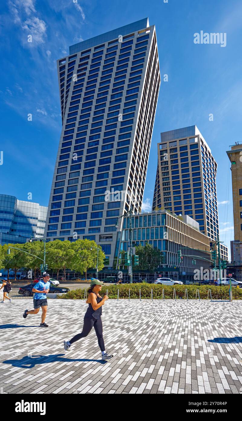 Läufer am Mittag im hellen Himmel am Hudson River Park, vorbei an der mit Korkenzieher geneigten One High Line. Stockfoto