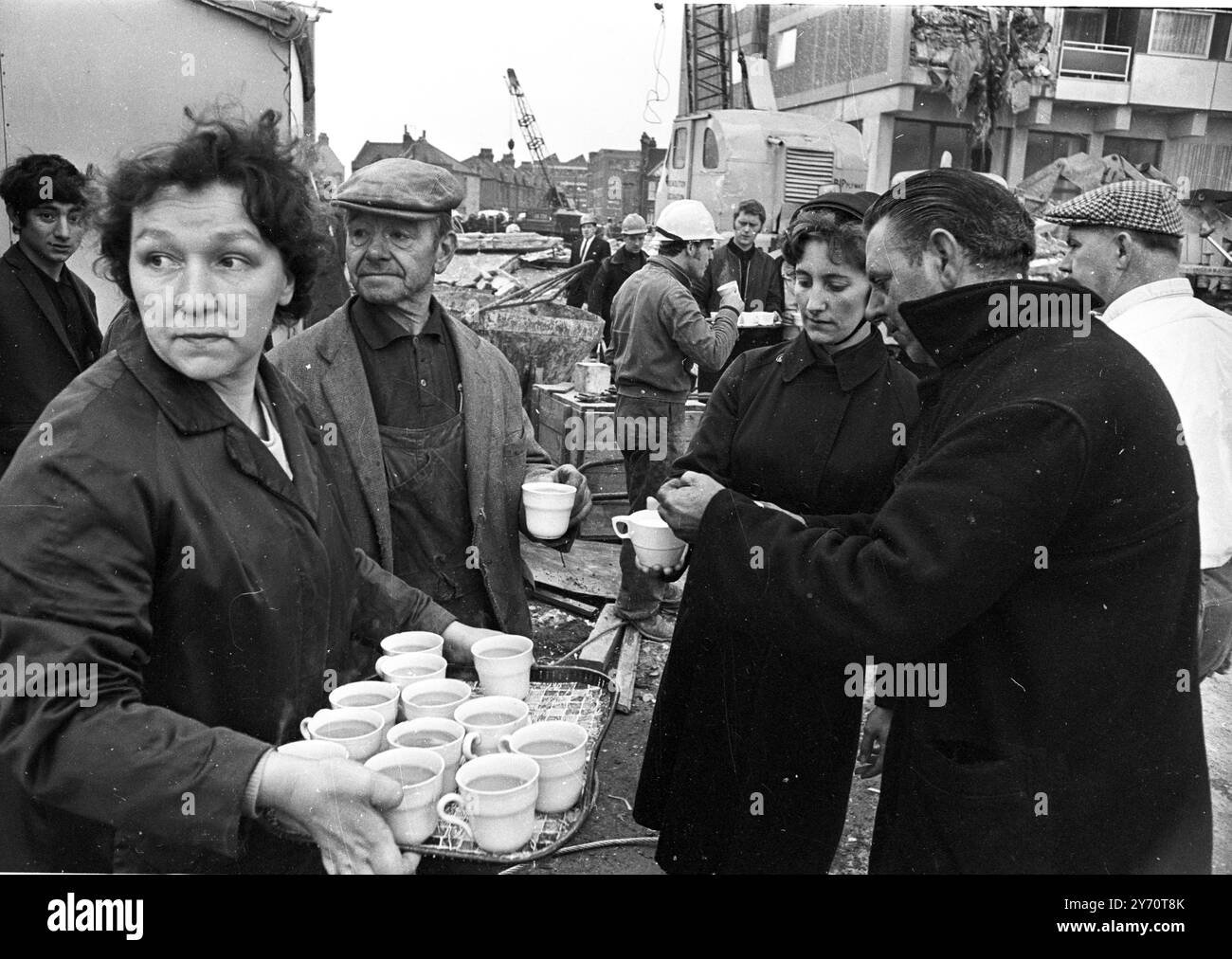 Mitglieder der Heilsarmee verteilen Begrüßungstee an die Arbeiter am Ort des heutigen teilweisen Einsturzes eines kürzlich fertiggestellten 23-stöckigen Wohnblocks im Customs House in East London . Der Zusammenbruch ereignete sich heute Morgen um 6 Uhr. Ein Augenzeuge sagte, es schien eine Explosion gegeben zu haben. Die jüngsten Zahlen sind drei Tote , Nine Verletzte und sieben , darunter drei verheiratete Paare , unberücksichtigt . Die Rettungseinsätze erfolgten später wegen der gefährlichen Situation, in der die Männer arbeiteten. - Der Turm ist auch bekannt als Ronan Point, benannt nach Dep Stockfoto