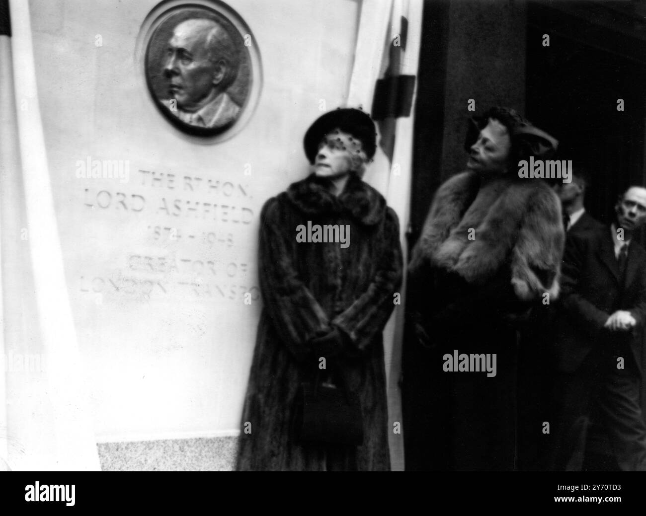 In einer intimen Zeremonie im Londoner Verkehrsgebäude am Broadway London stellte der Verkehrsminister Alfred Barnes eine Gedenktafel des Leiters des verstorbenen Lord Ashfield vor , der das Londoner Verkehrssystem in seiner heutigen Form schuf . Lady Ashfield schaut sich die Gedenktafel nach der heutigen Enthüllungszeremonie an , beobachtet von Lady Latham , der Frau des Vorsitzenden der London Transport Executive . 16. Mai 1950 Stockfoto