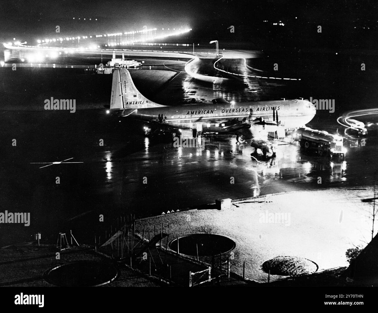 Der Flughafen Prestwick , das Zentrum eines schottischen Inlandsstreits , ist Tag und Nacht ein Hort von Aktivität . Über sein Landefeld brüllen bei jedem Wetter die Flugzeuge von einem halben Dutzend internationalen Fluggesellschaften . Britisch Kanadier , Amerikaner , Niederländer , Franzosen und Skandinavier . Gesehen am Flughafen Prestwick um Mitternacht , mit dem glitzernden Asphalt reflektiert die unzähligen blinkenden Landungslichter . 18. Januar 1950 Stockfoto
