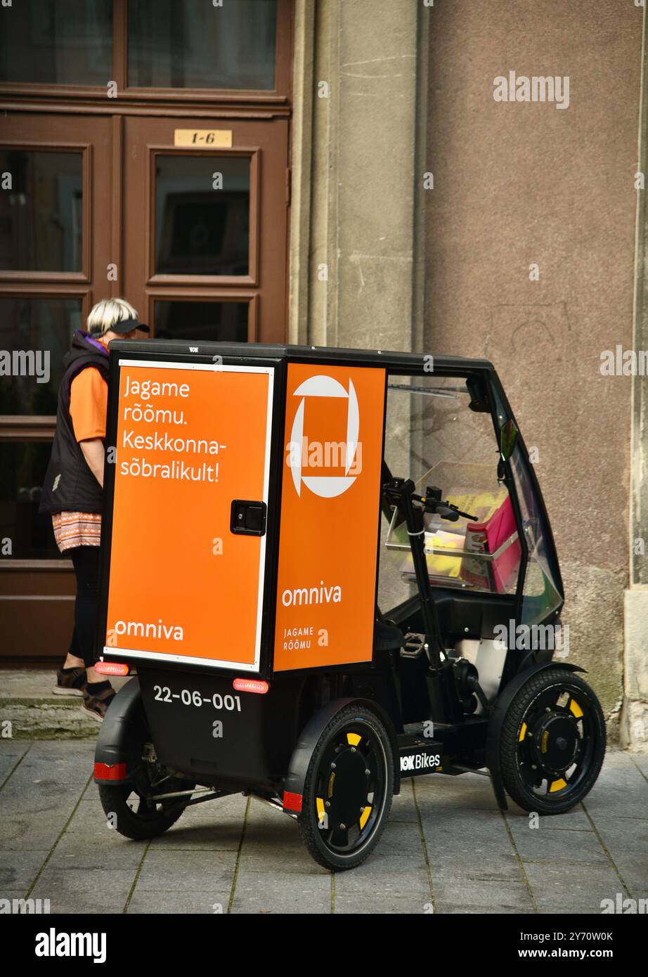 Pedalantrieb Omniva Postzustellung EV Fahrzeug Vok Bikes mit Paketaufbewahrung, Lieferung in der Altstadt auf Kopfsteinpflasterstraßen Tallinn, Estland. Stockfoto