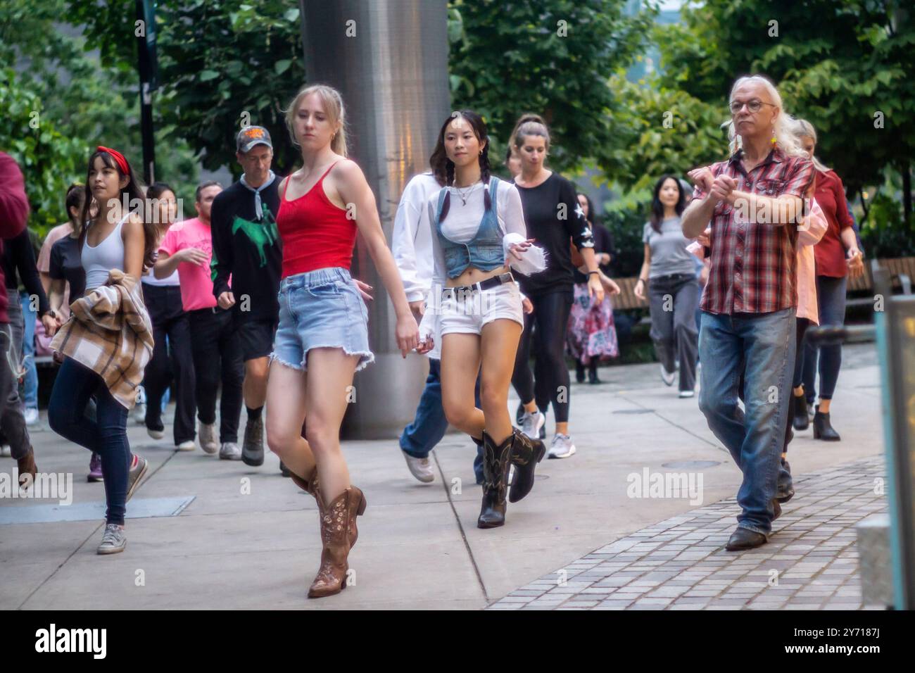 New Yorker und Besucher tanzen im Bella Abzug Park in New York am Mittwoch, den 26. September 2024 während des Line Dancing Workshops im Park. Am Abend zogen die Tänzer ihre Stiefel an und tanzten einen Sturm in der Werkstatt der Big Apple Ranch. Der Tanz ist nur eine der vielen Aktivitäten, die die Hudson Yards Hells Kitchen Alliance im Bella Abzug Park durchführt. (© Richard B. Levine) Stockfoto