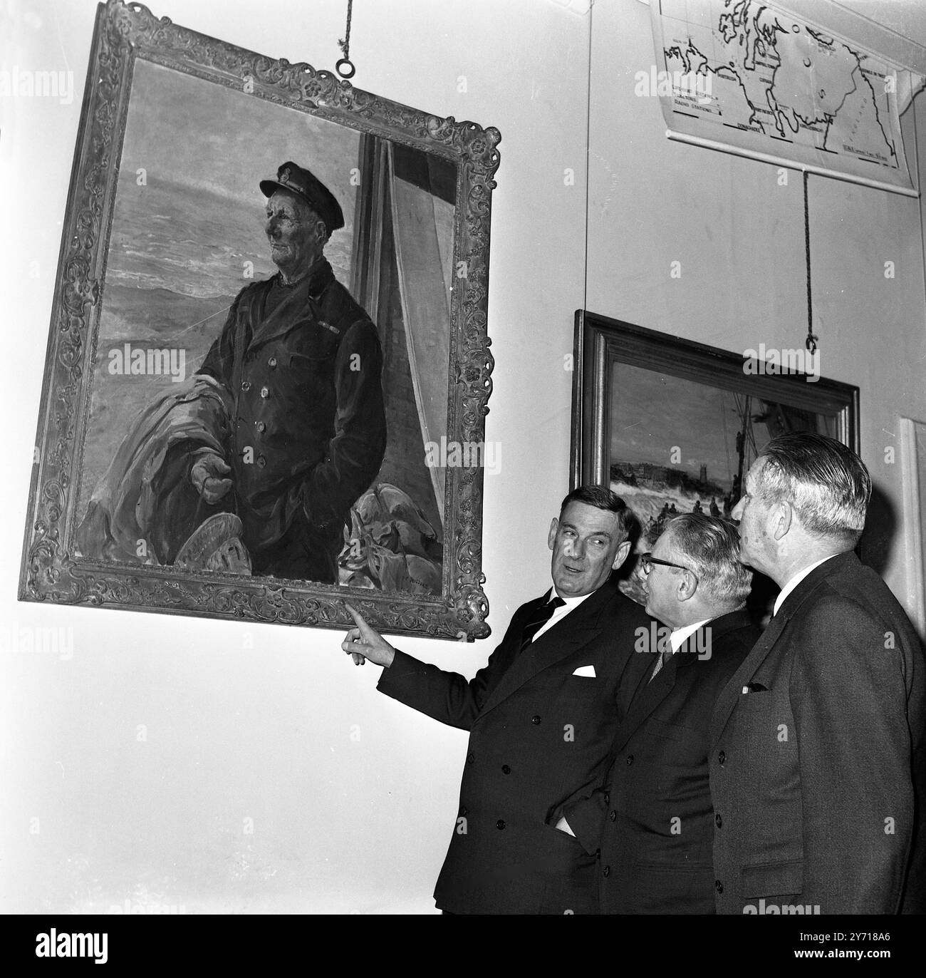 Der britische Chief Inspector of Rettungsboots Commander Dutton (links) beschreibt ein Gemälde von Großbritanniens berühmtestem Rettungsboot-Coxswain Henry Blogg , G.C. , BEM an Captain Rogerio Pinto ( Mitte) und Captain Carlos Carre Ira ( rechts ) , Mitglieder der portugiesischen Rettungsbootgesellschaft , im Londoner Hauptquartier der Royal National Lifeboat Institution . Die portugiesischen Rettungsbootbeamten besuchen das Vereinigte Königreich zu einem fünftägigen Besuch , um RNLI-Einrichtungen und das Board of Trade zu besuchen . 6. April 1970 Stockfoto