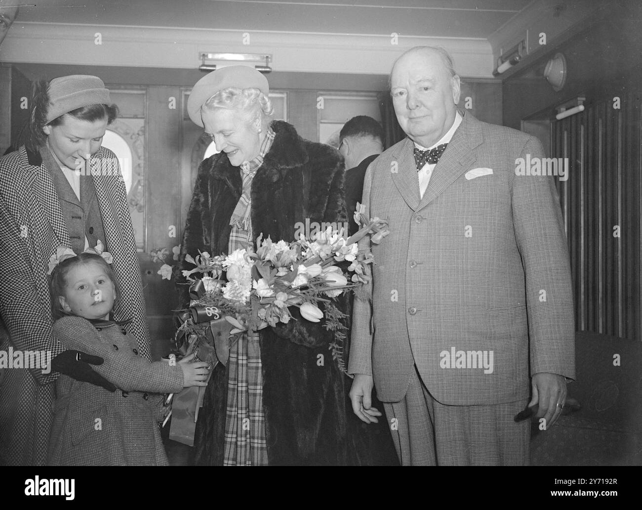 BLUMENSTRAUSS FÜR FRAU . CHURCHILL Mrs. CHURCHILL wird von der fünfjährigen MARY GAY BEMBRIDGE , Tochter der konservativen Kandidatin für Southampton, mit einem Blumenstrauß überreicht , bevor der Cunard White Star-Linienschiff Queen Elizabeth New York nach Southampton verließ . Herr Churchill ( an der Seite seiner Frau ) wird mit Frau Churchill nach Amerika reisen , um eine Ansprache vor den Mitgliedern des Massachusetts Institute of Technology in Boston zu halten . Er besucht auch Washington und New York. 18. März 1949 Stockfoto